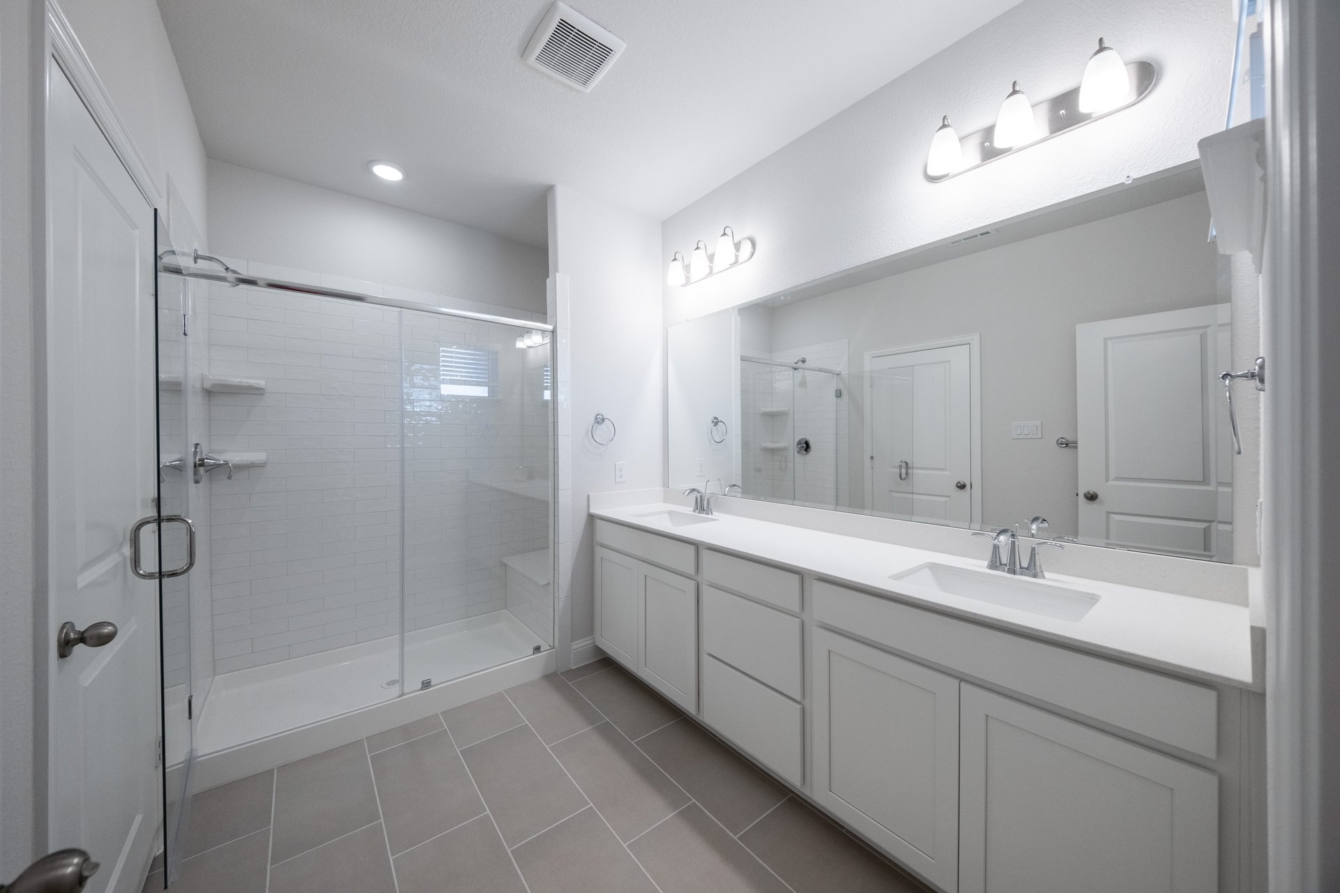 bathroom with large walk-in shower and white countertops 