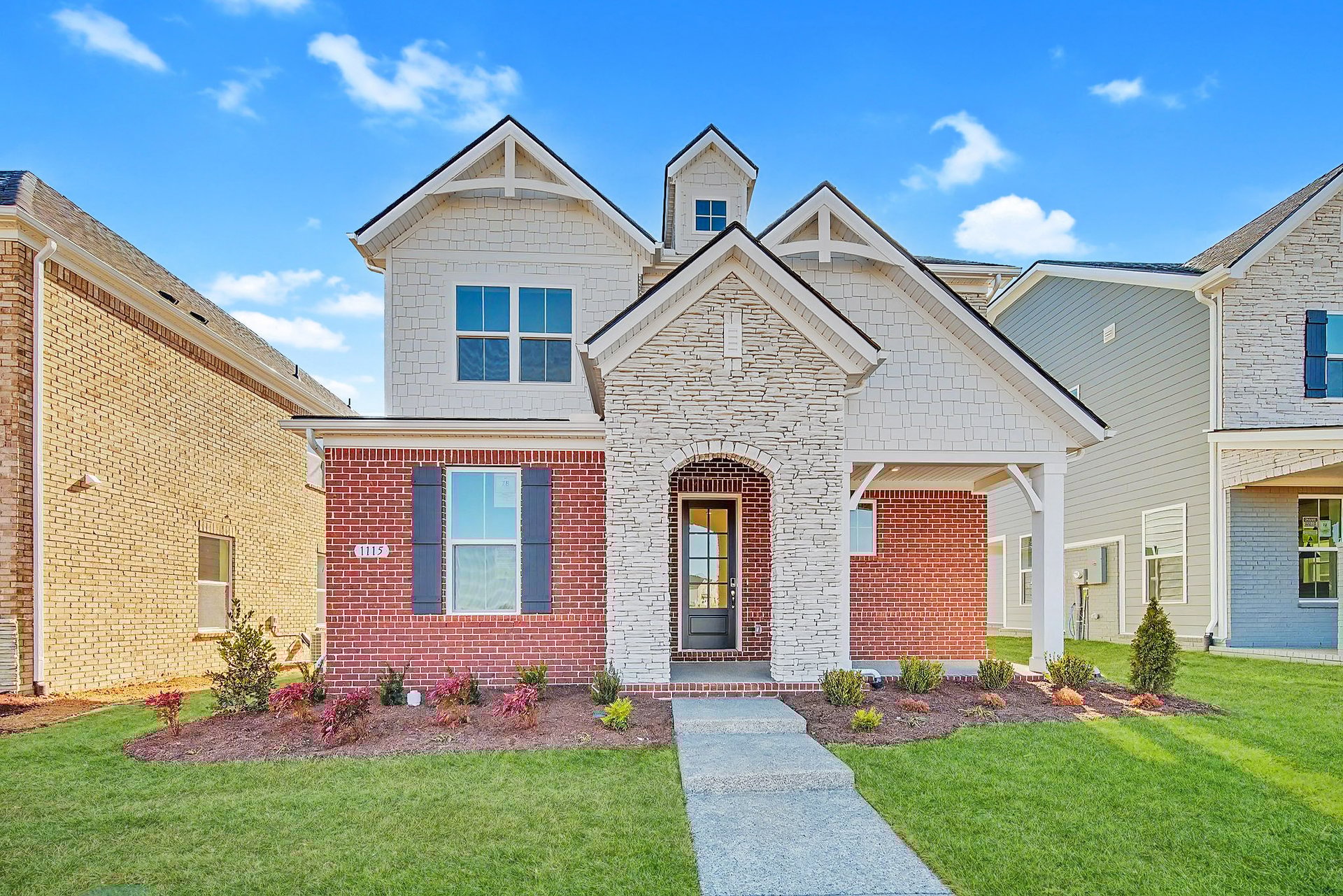 exterior with brick and a stone arch over a covered front porch