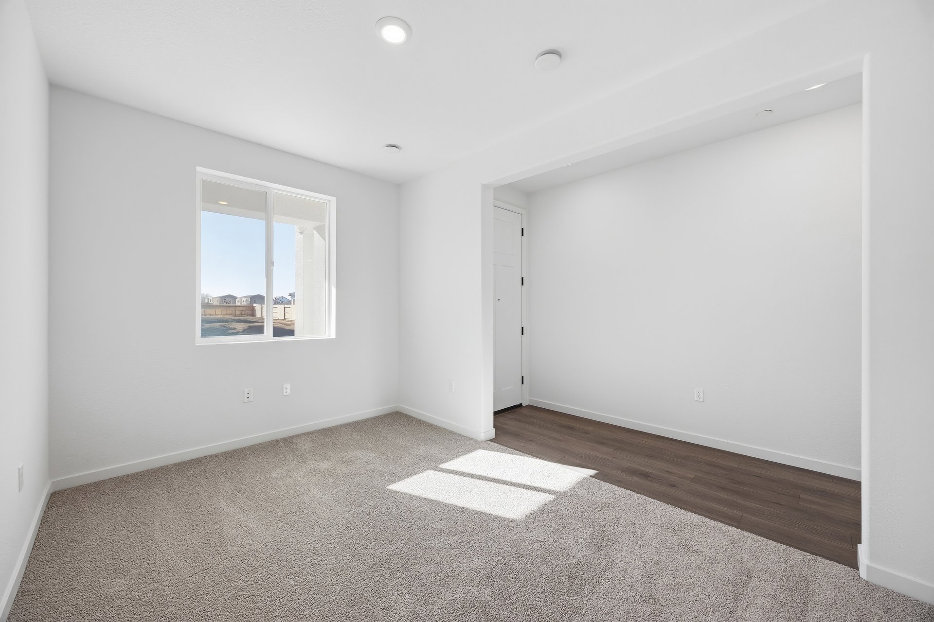 study with tan carpet, white walls, window, and view of entry foyer