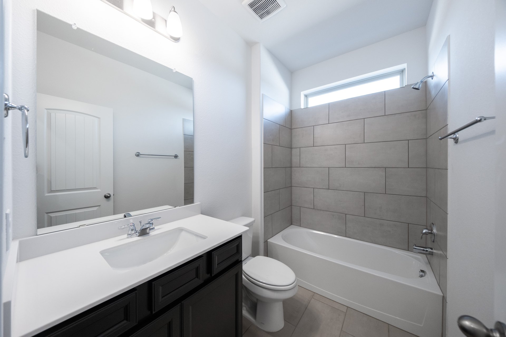 bathroom with dark cabinets and white countertops 
