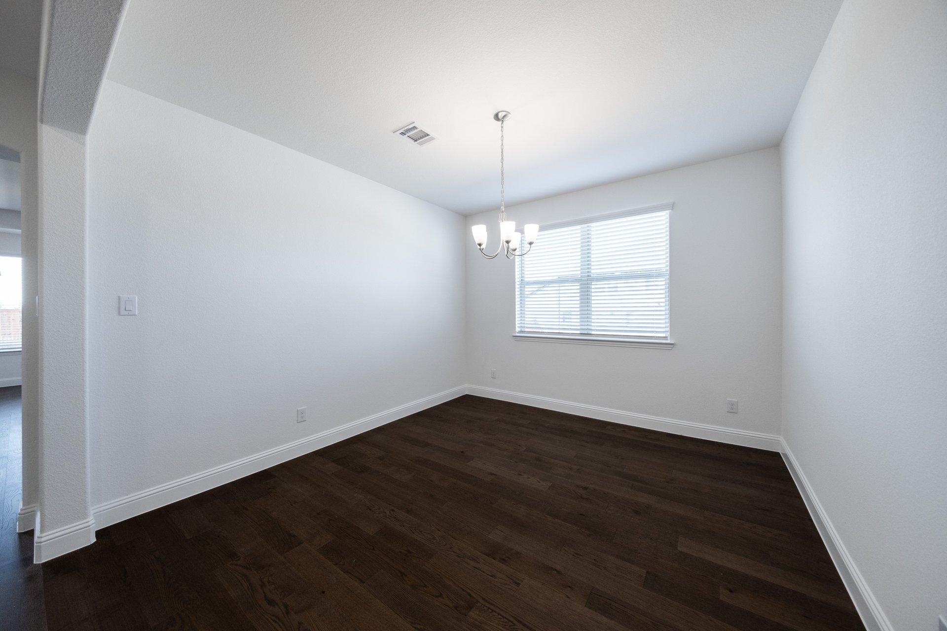 dining room with wood flooring and window with blinds 