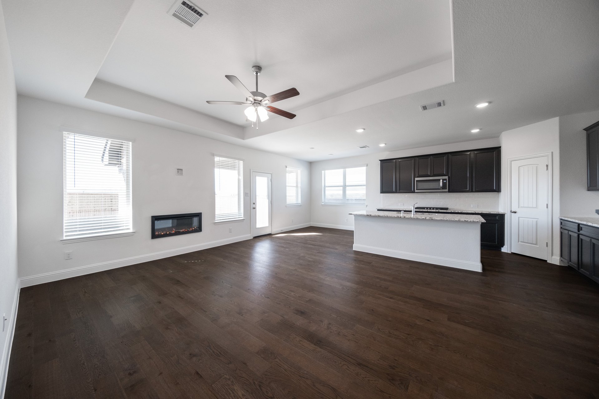 great room with fireplace and wood flooring 