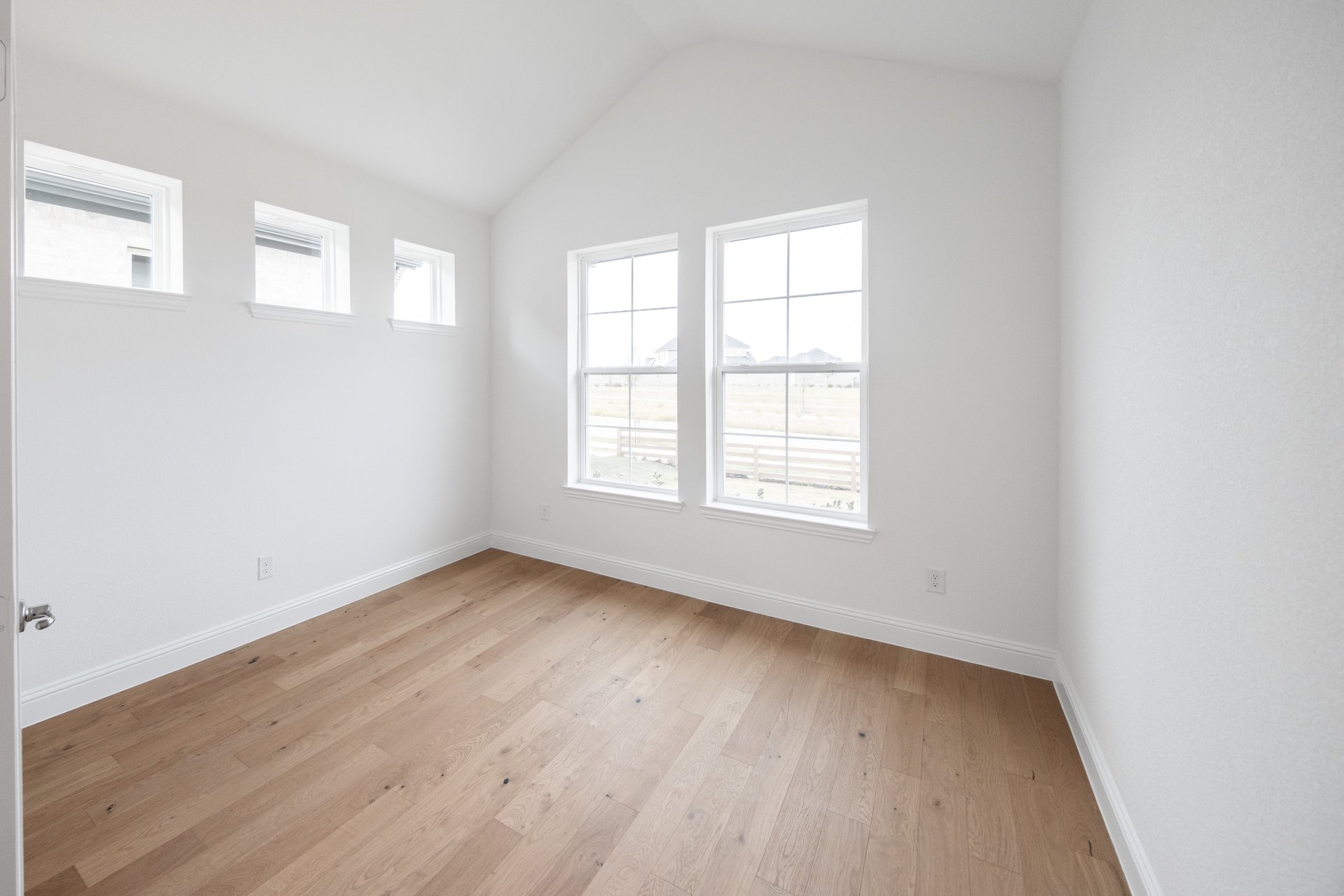 study with wood flooring and large windows
