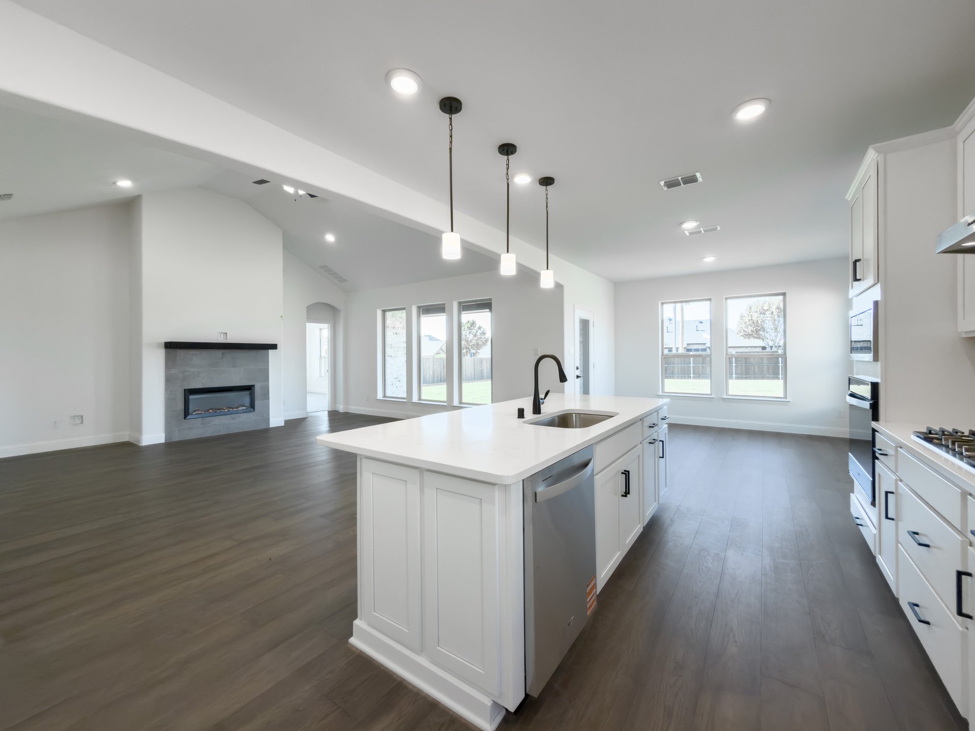 open kitchen with wood floors and white cabinets