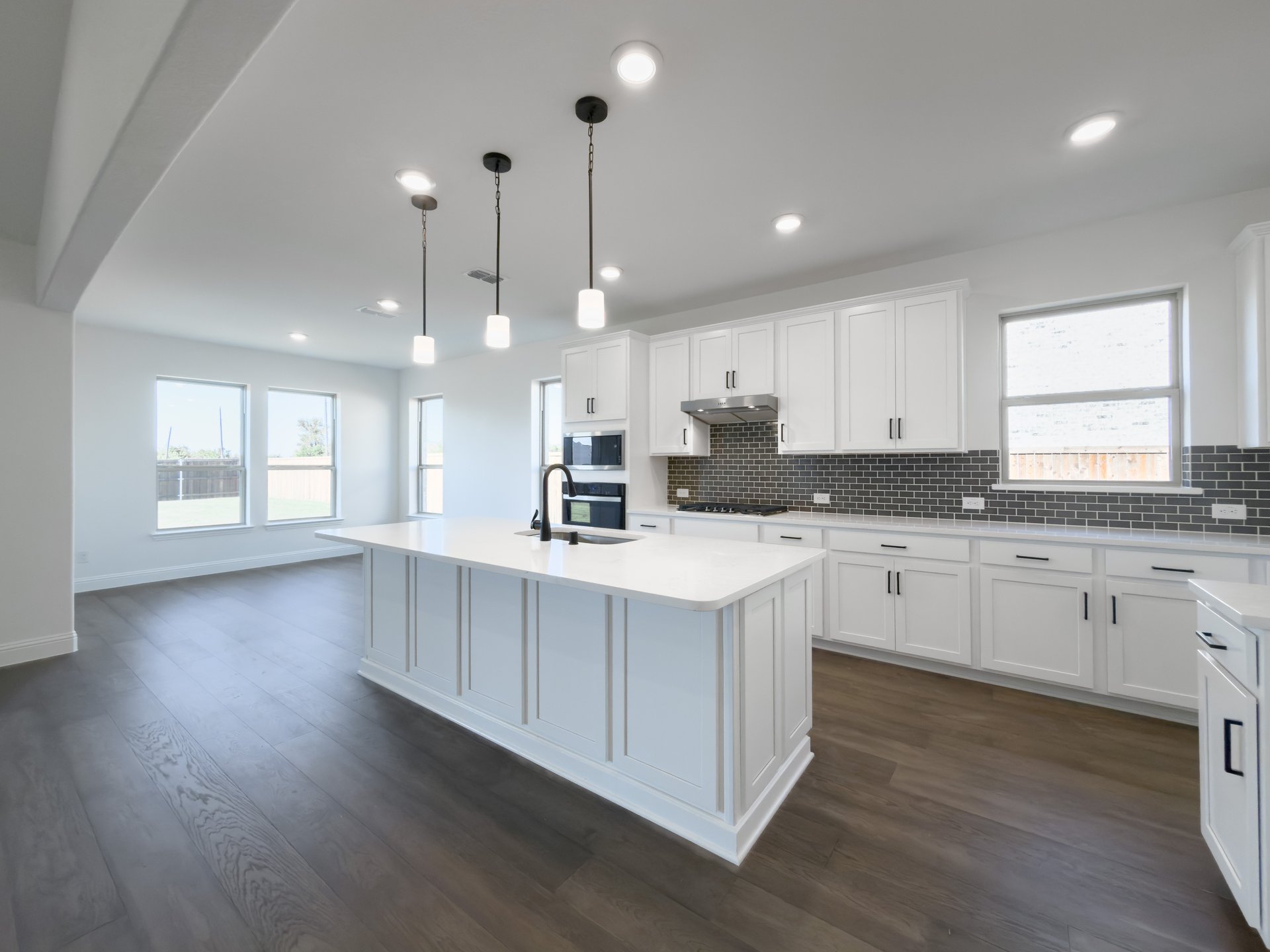 open kitchen with wood floors and white cabinets