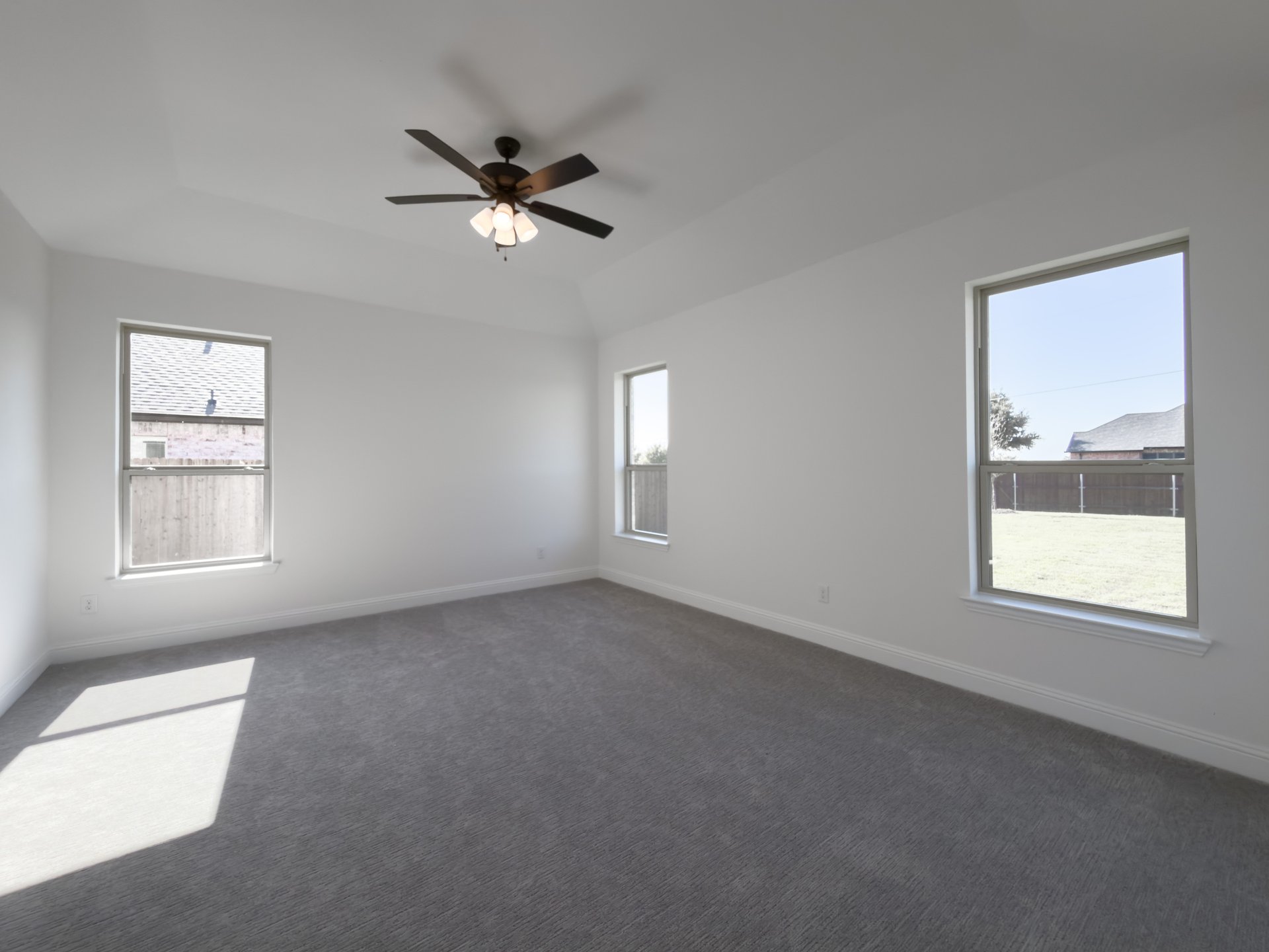 primary bedroom with carpet and windows