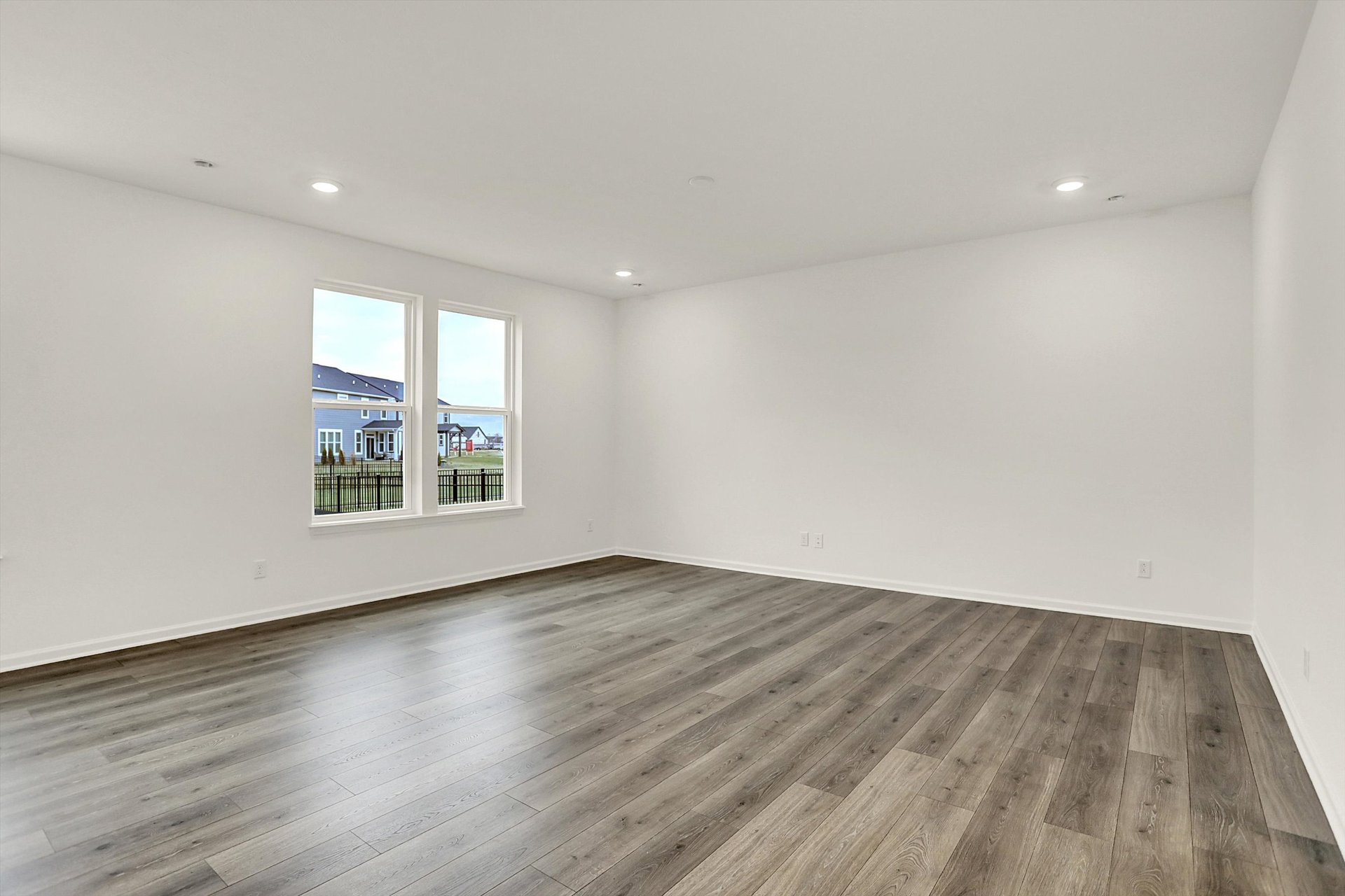 great room with wood plank flooring and white walls