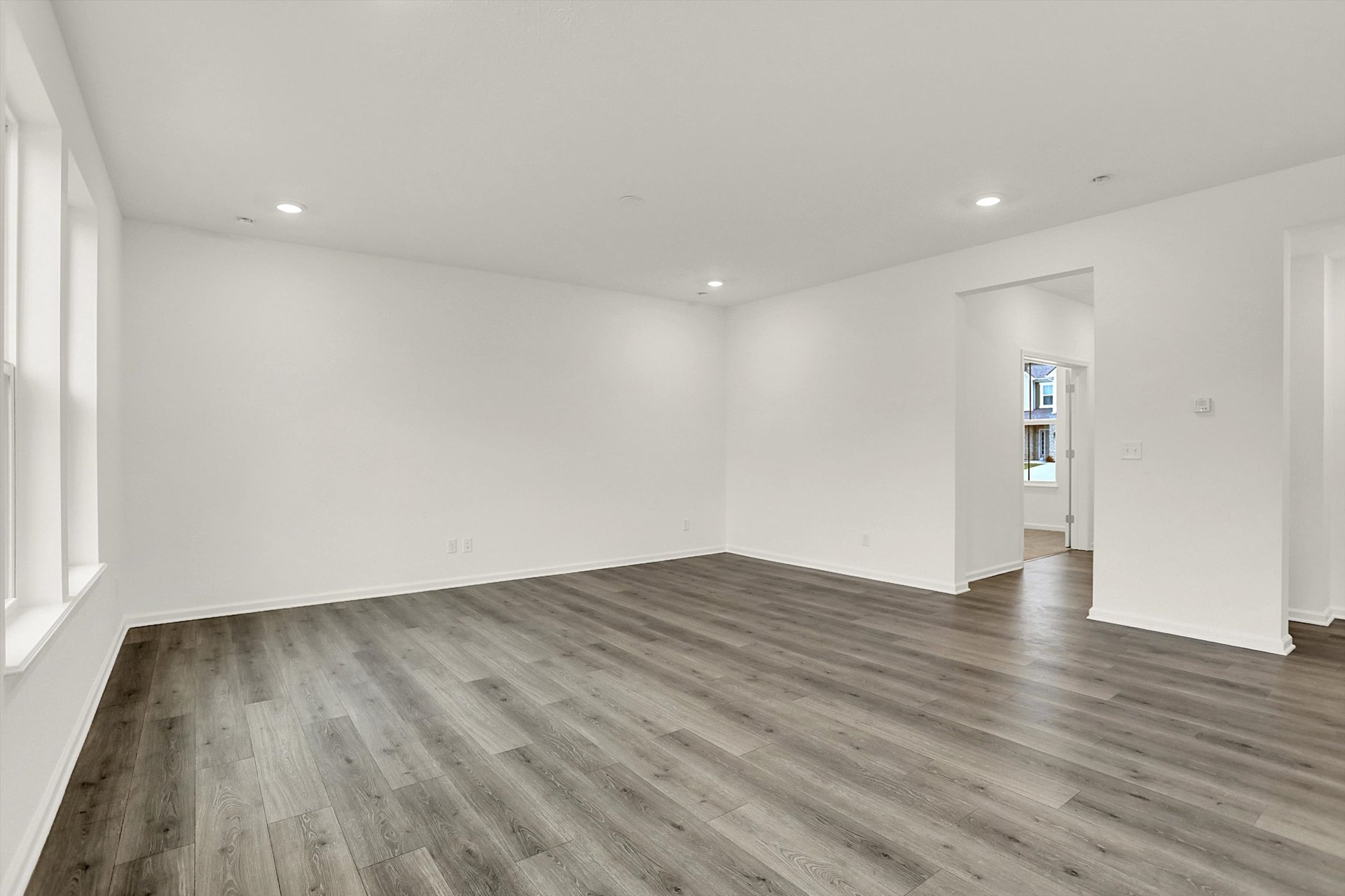 great room with wood plank flooring and white walls