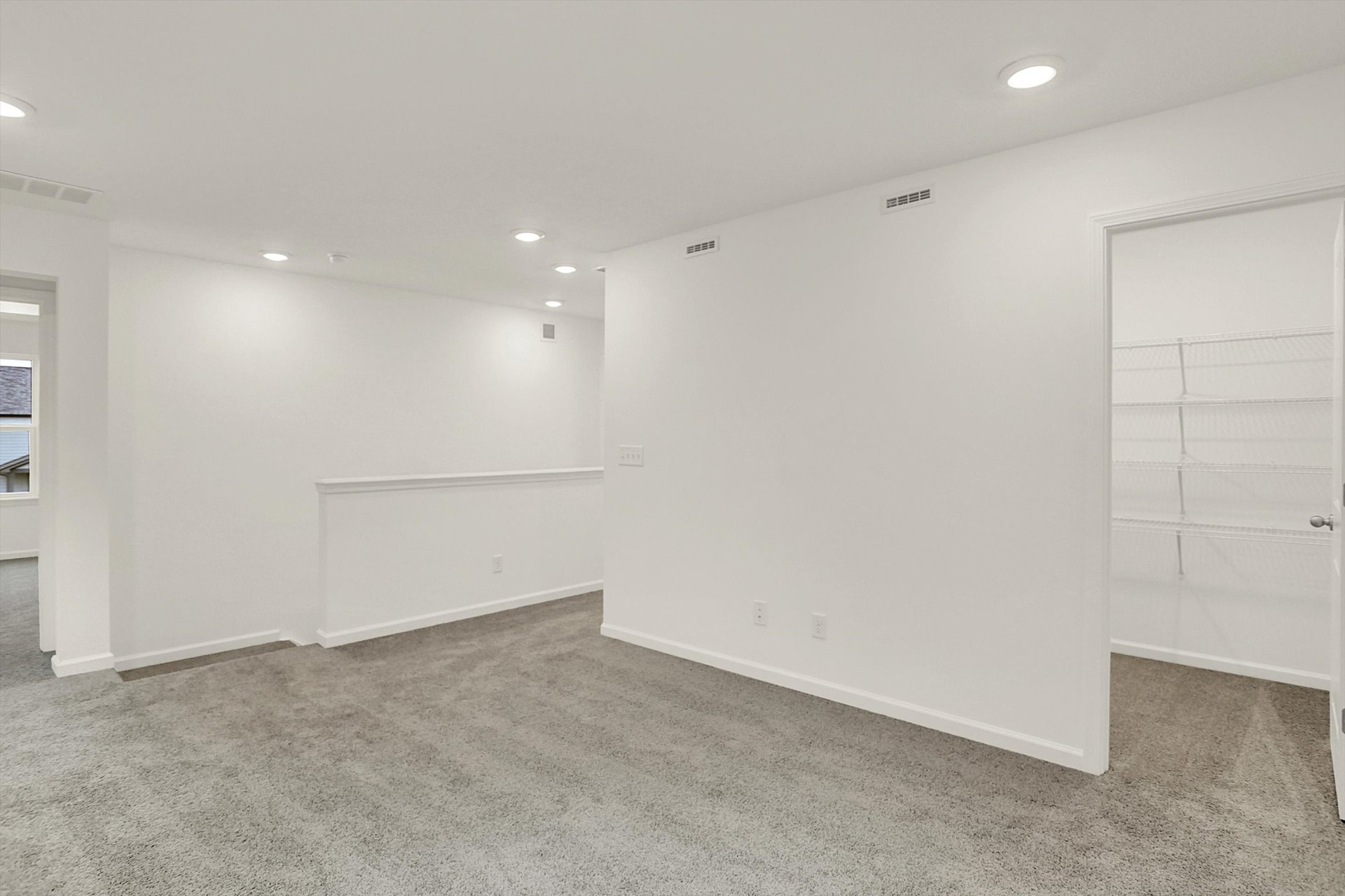 loft with tan carpet and white walls