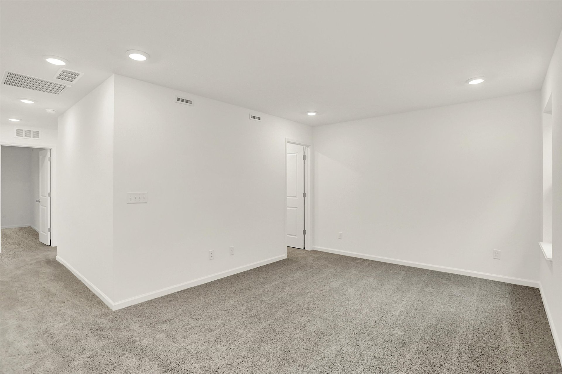 loft with tan carpet and white walls