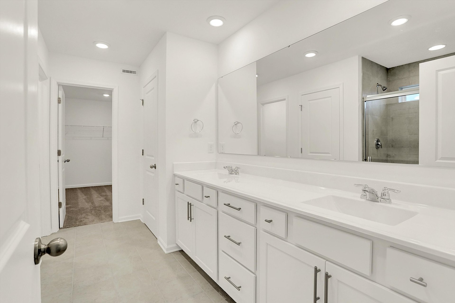 bathroom with white cabinets and dual sink vanity
