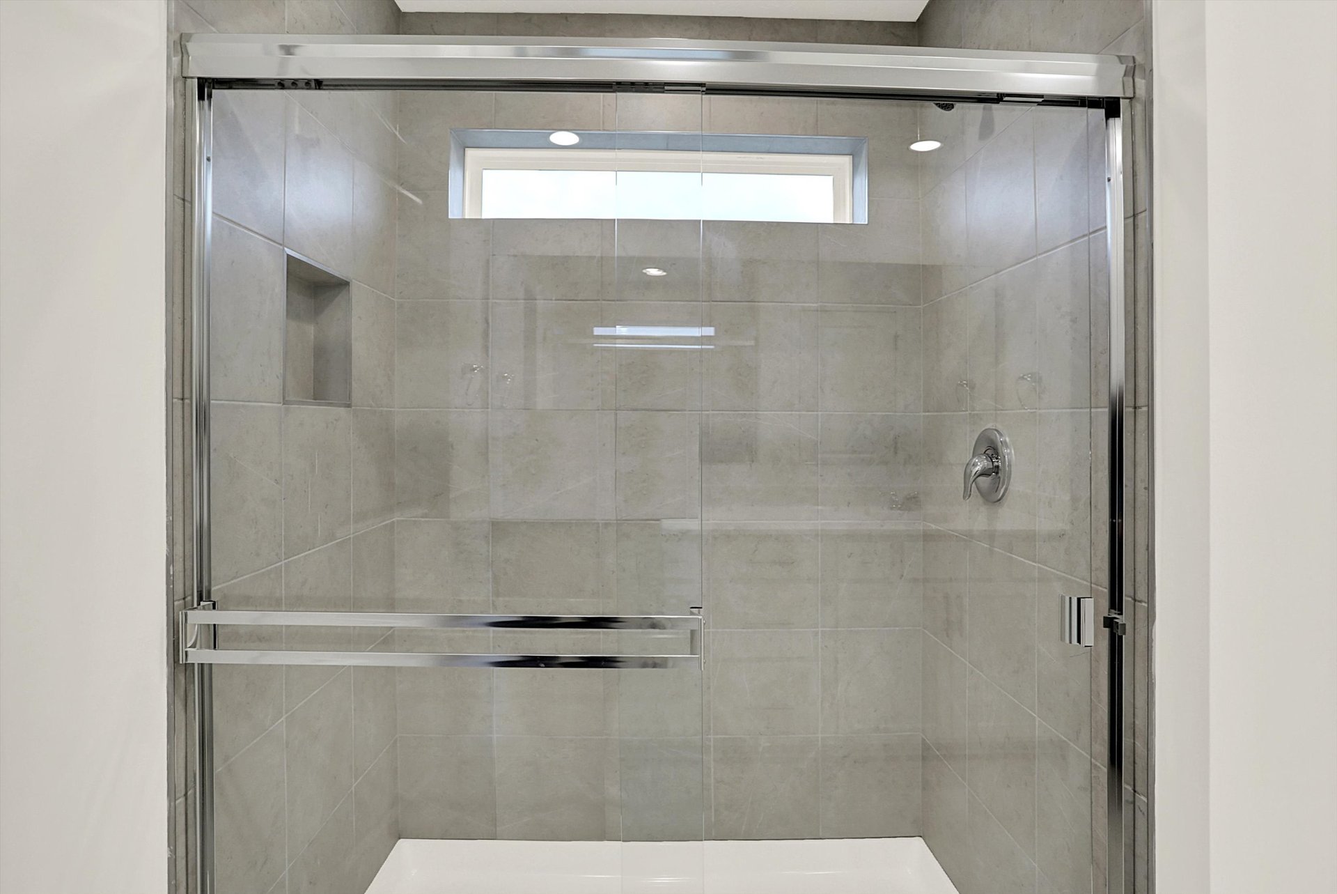 bathroom with gray tile walk-in shower