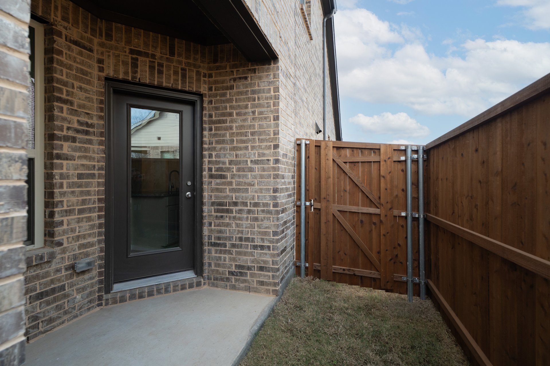 covered patio that opens to small fenced yard