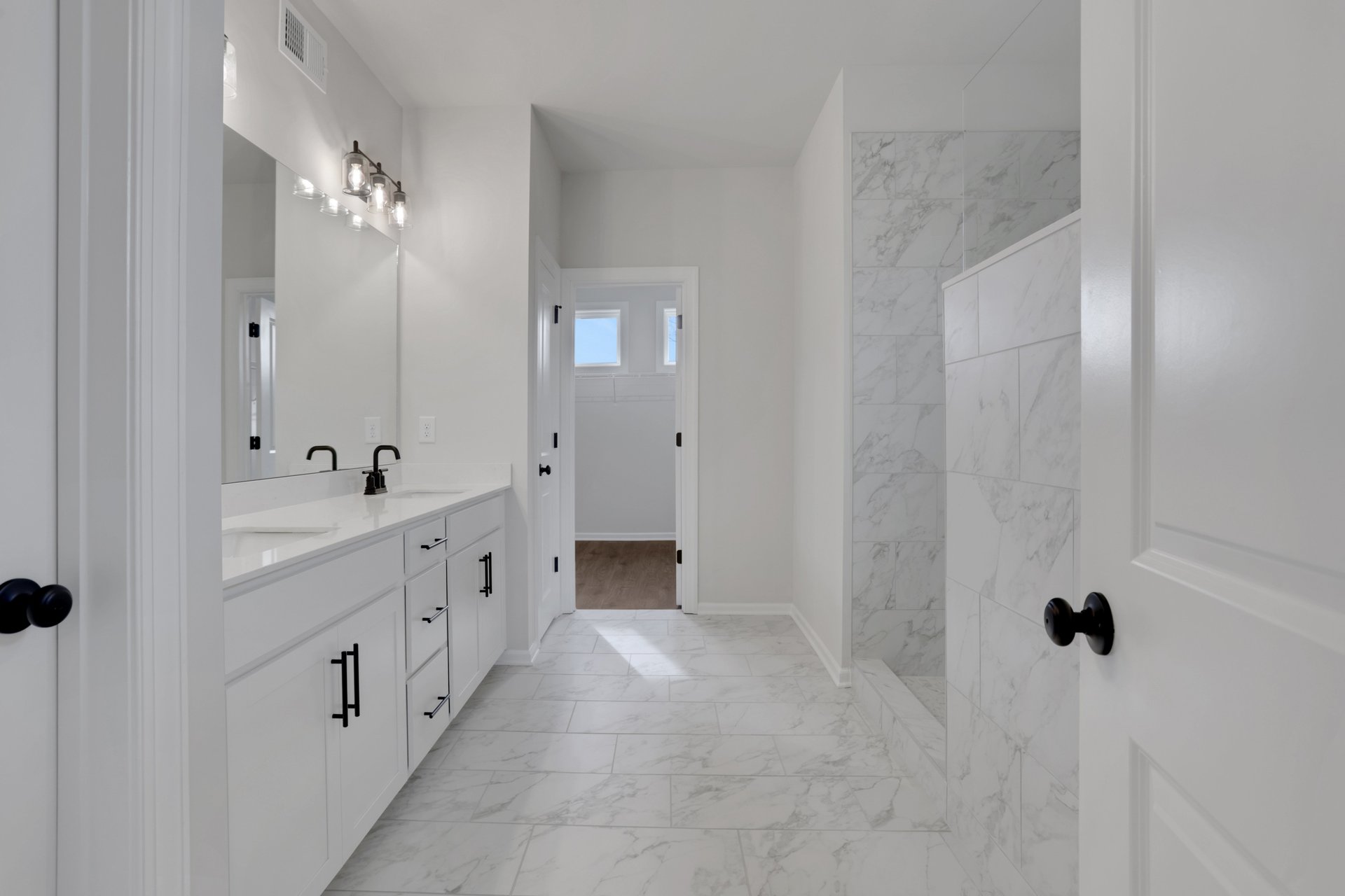 primary bathroom with white cabinets and tile flooring