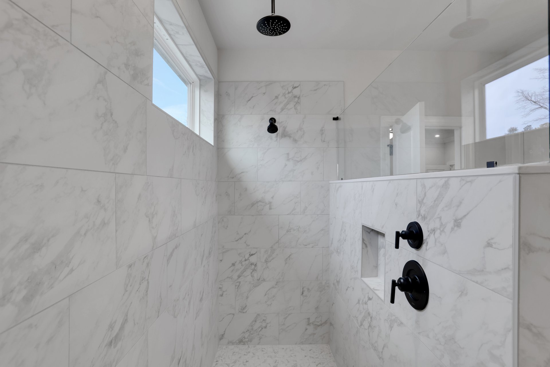 primary bathroom with large walk-in shower with tile