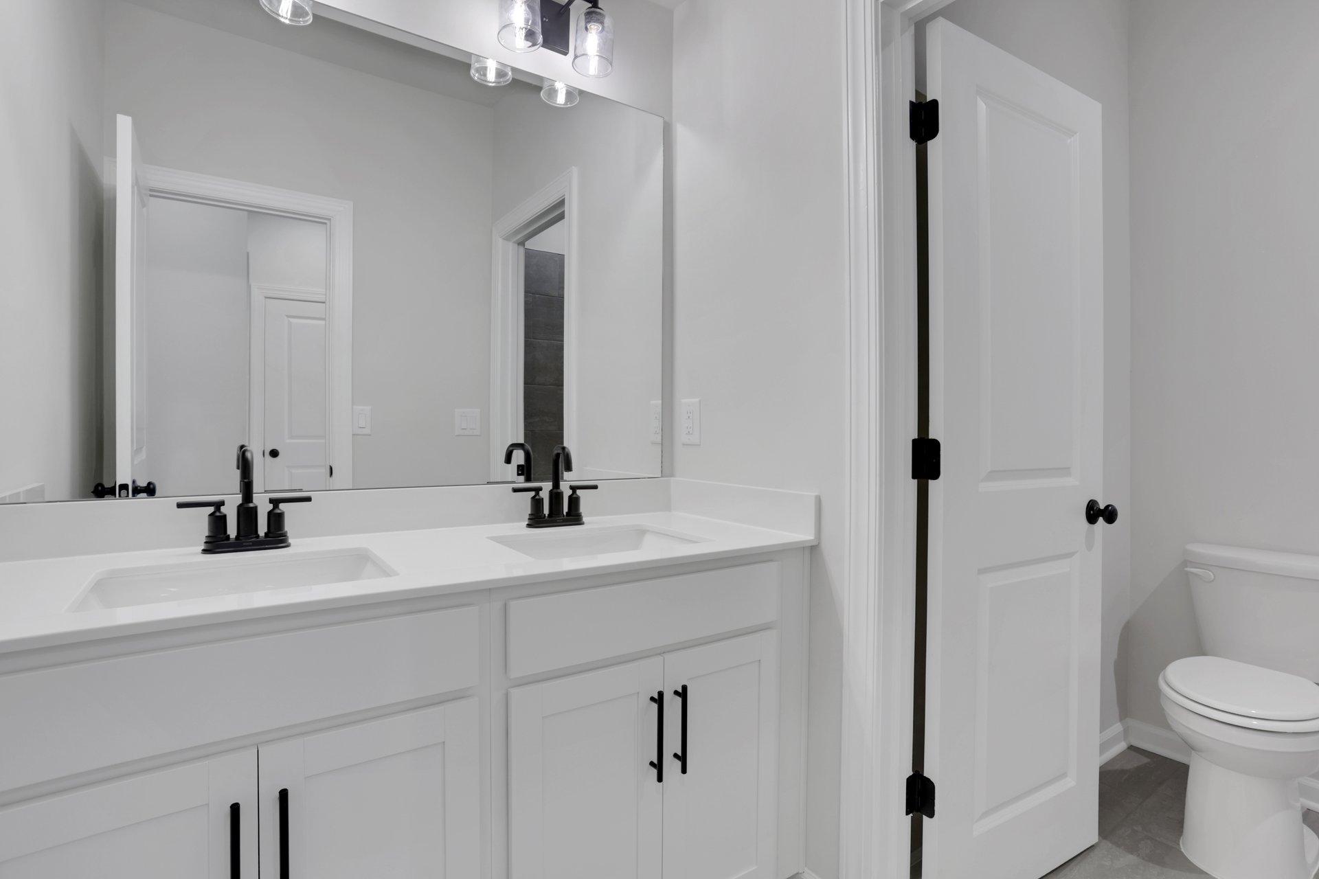 secondary bathroom with white cabinets and tile flooring