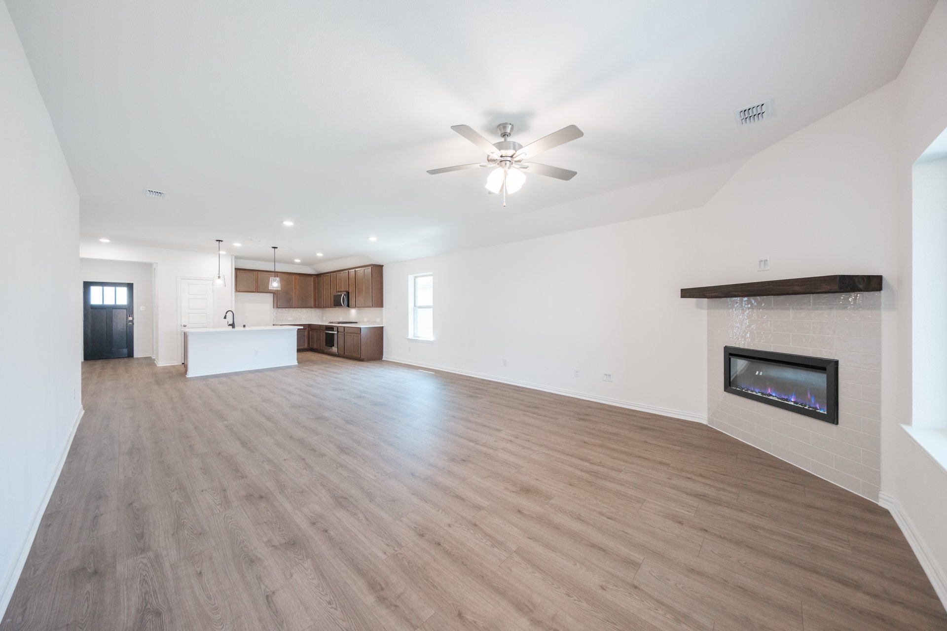 open great room with wood floors and ceiling fan