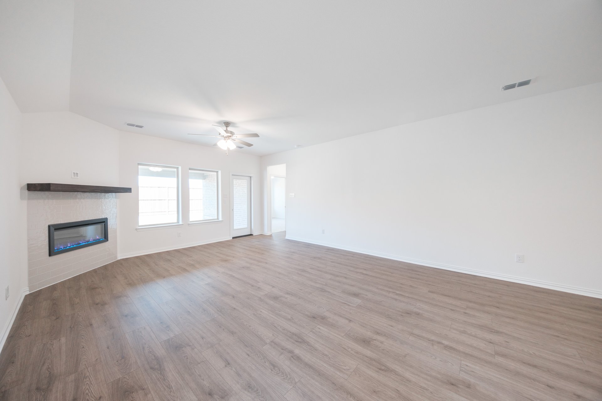 open great room with wood floors and fireplace