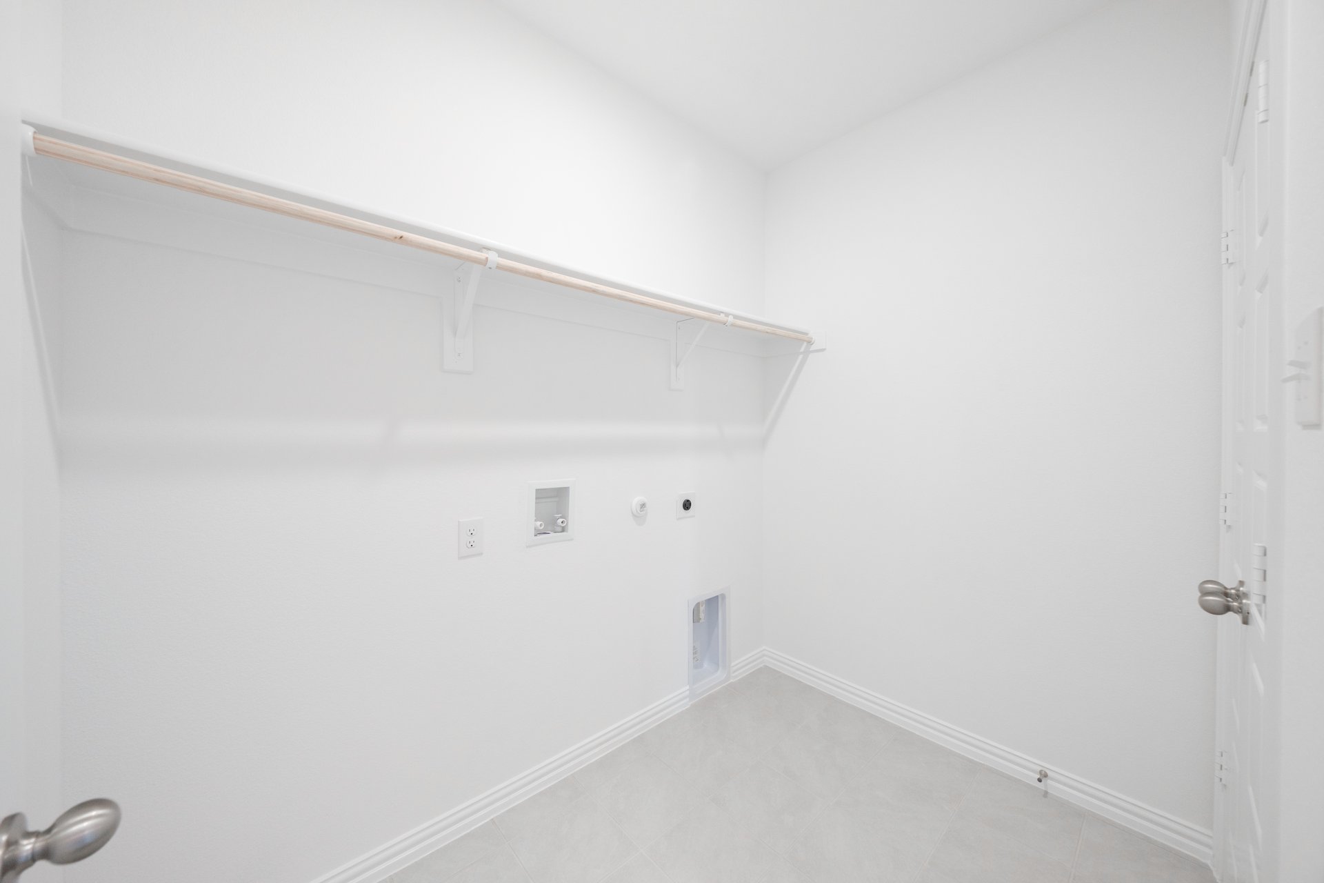laundry room with tile floors and white shelf