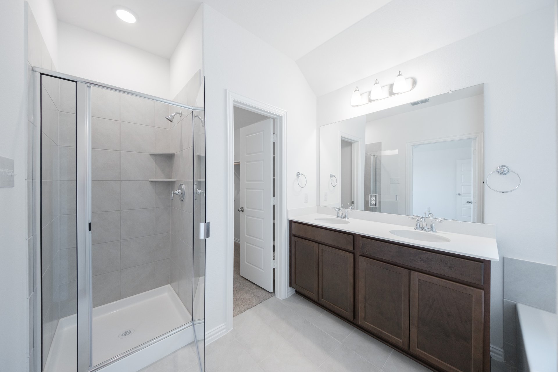 primary bathroom with walk-in shower and tile floors
