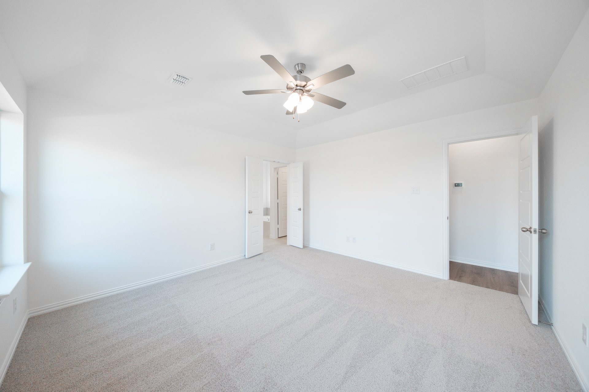 primary bedroom with carpet and ceiling fan