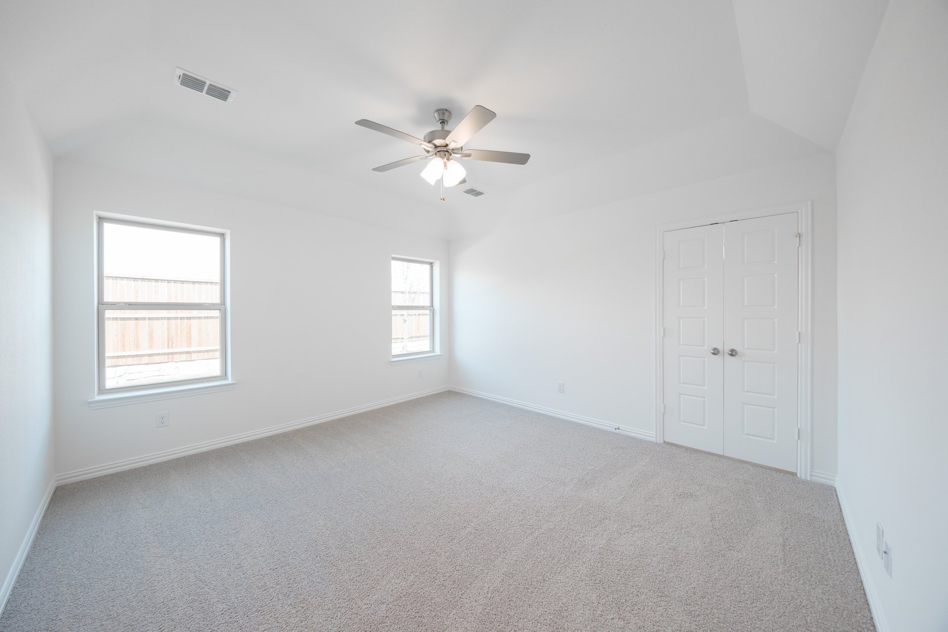 primary bedroom with carpet and windows