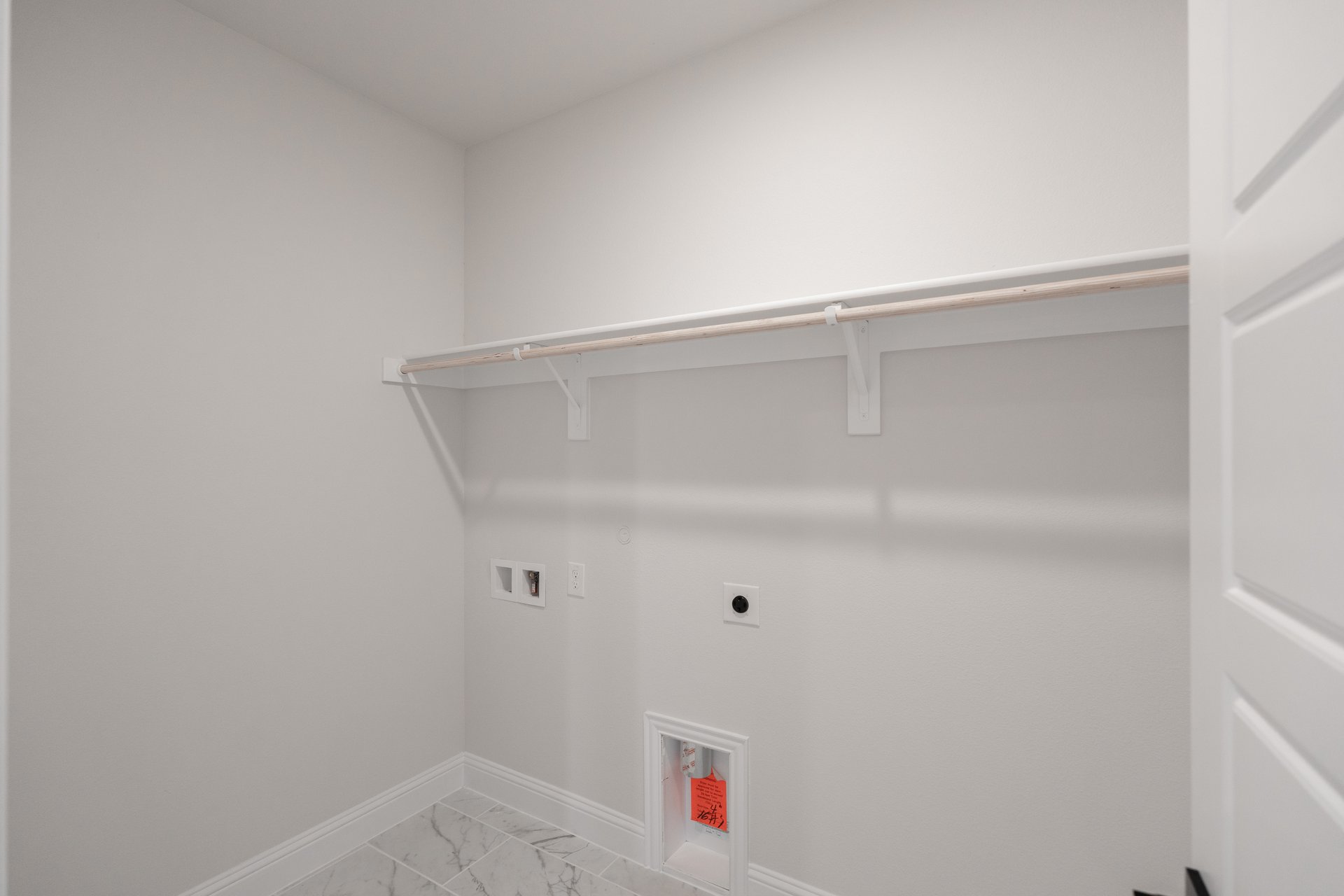 laundry room with tile floors and white shelf