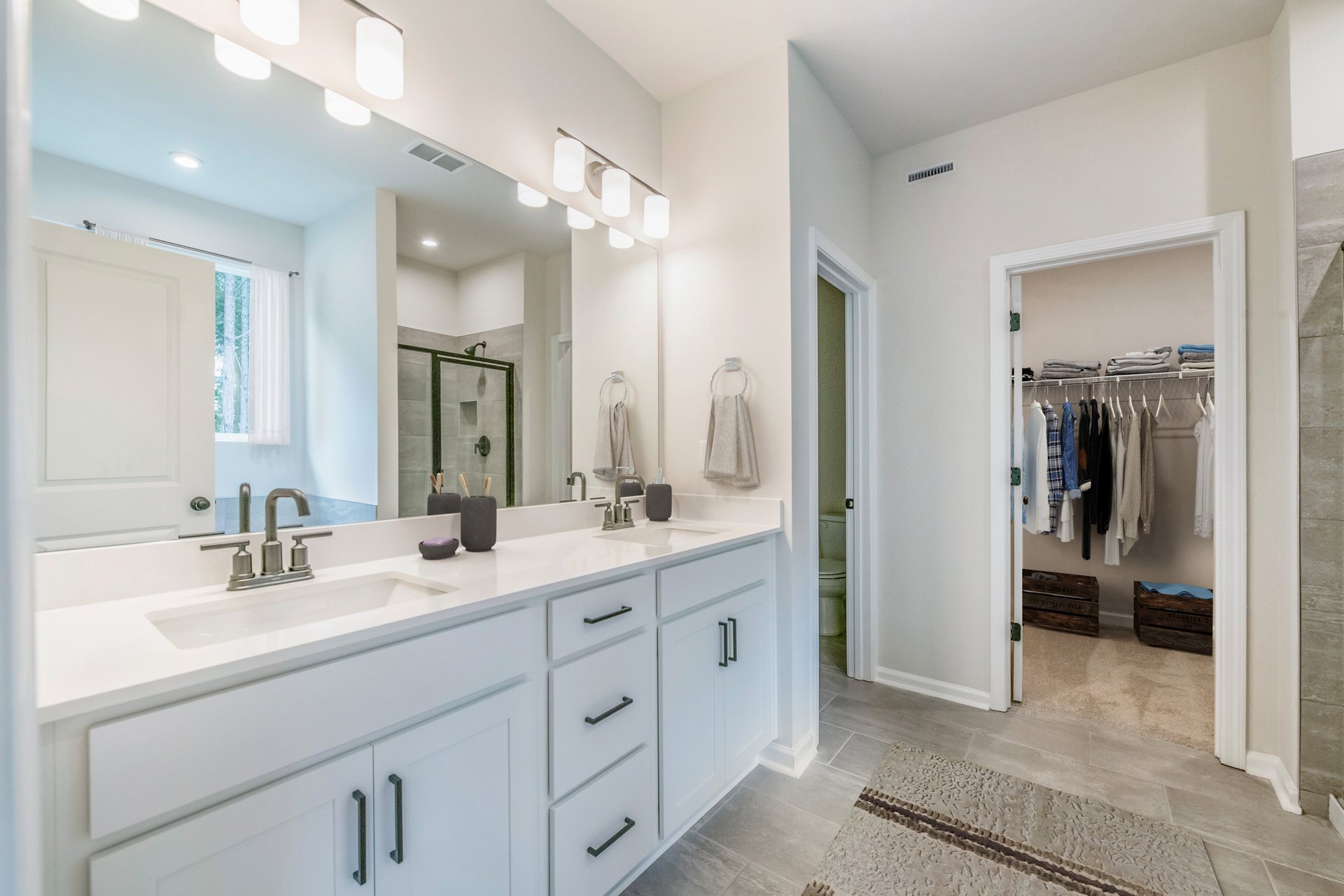 primary bathroom with white cabinets and tile floors