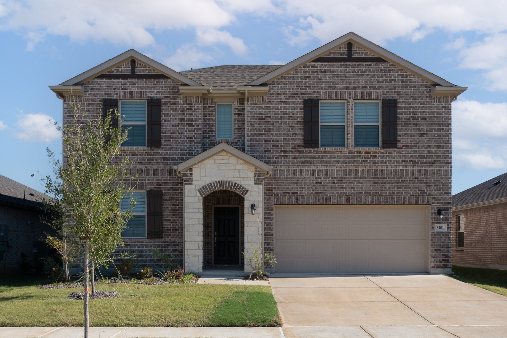 exterior of home with brown brick and white stone