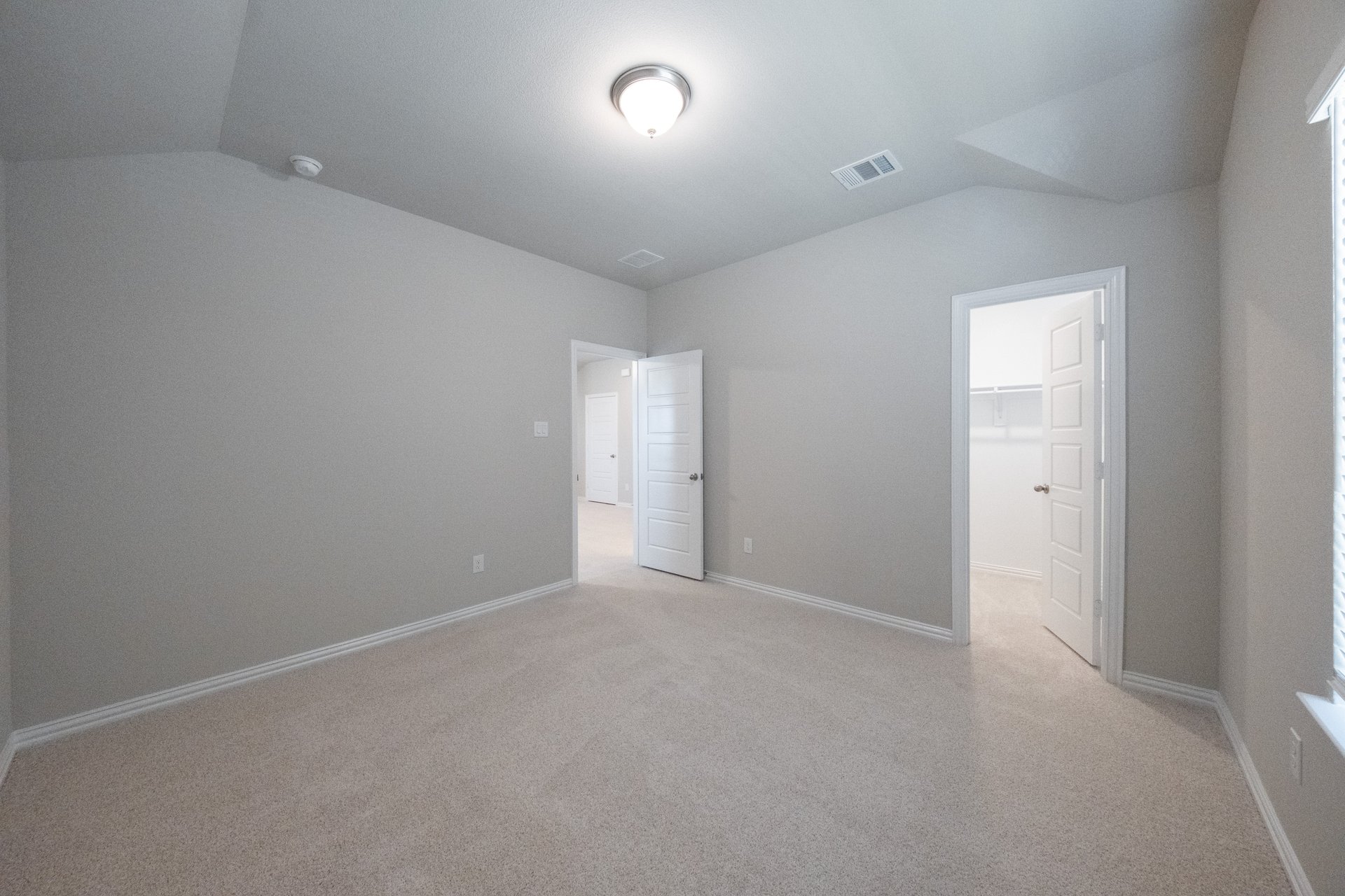 guest bedroom with carpet and walk-in closet