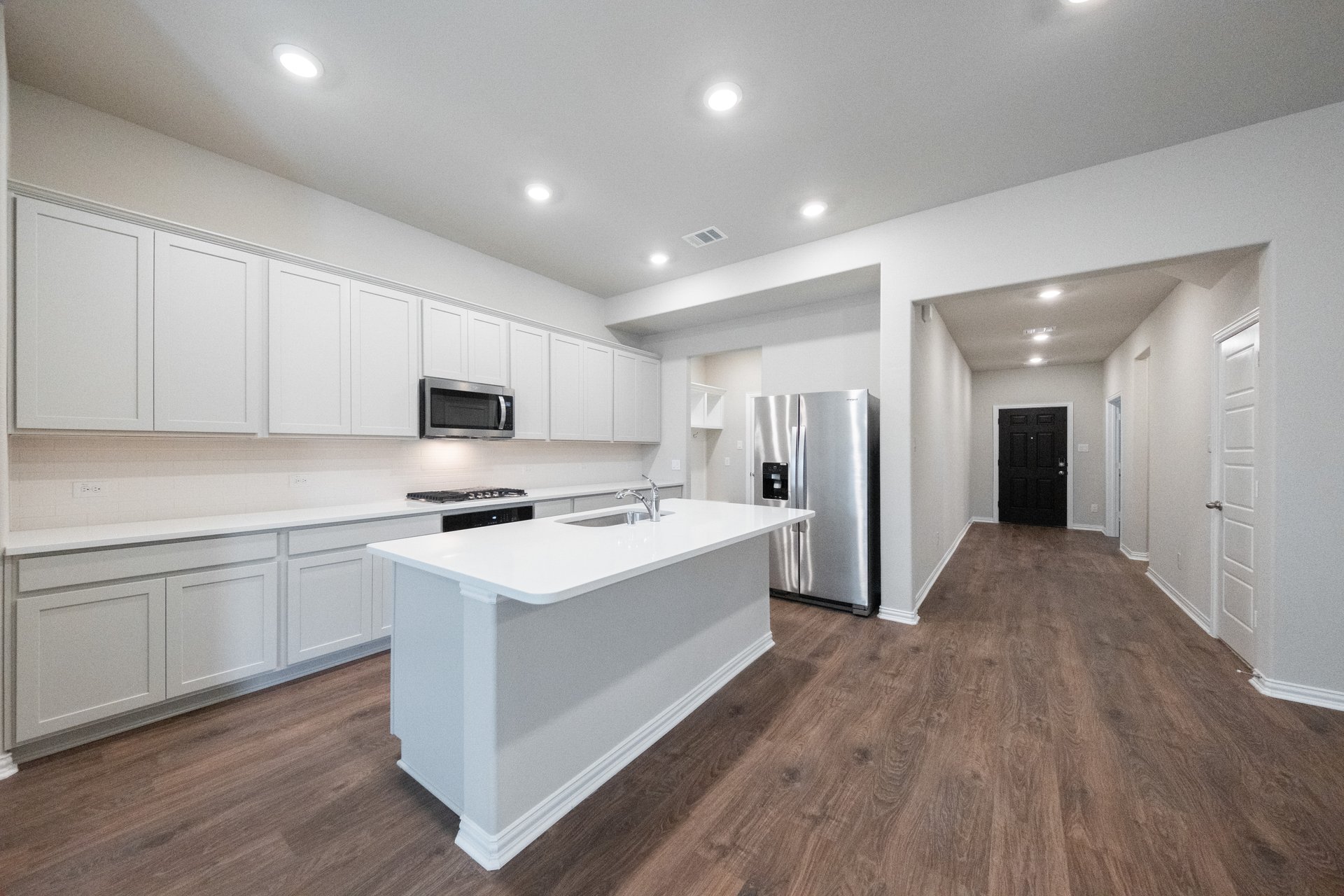 open kitchen with white cabinets and hardwood flooring