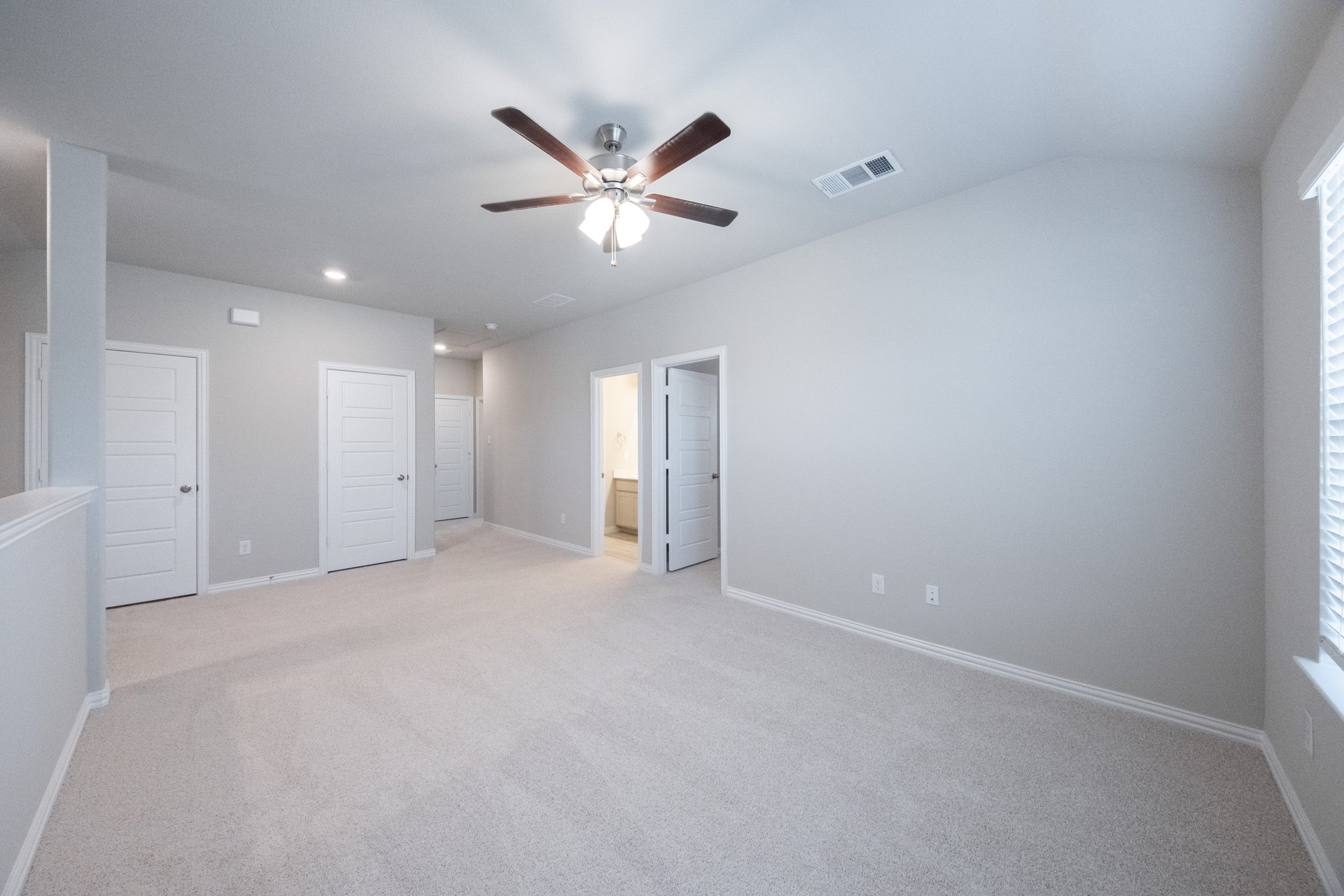 spacious loft with carpet and ceiling fan