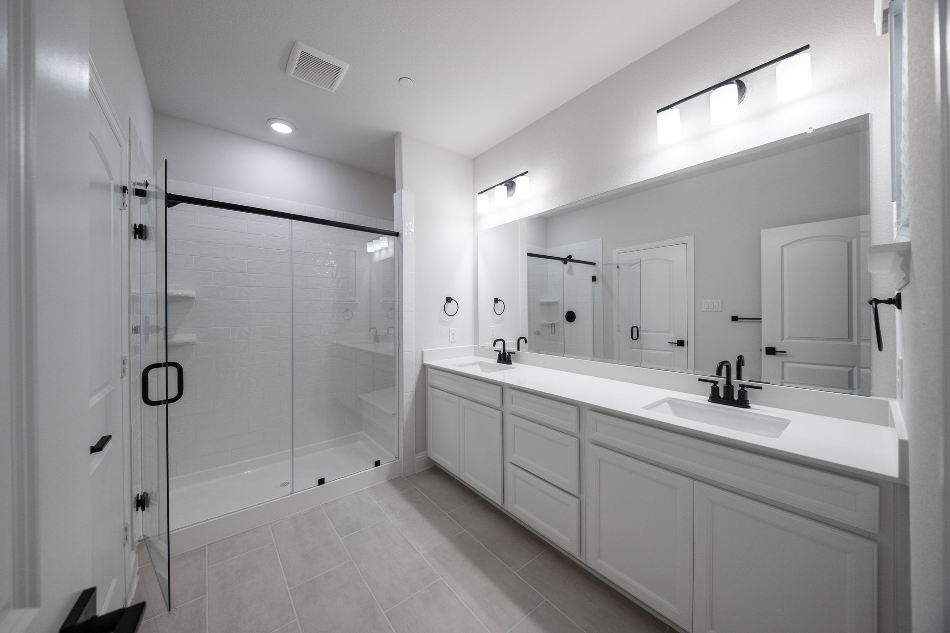 bathroom with large walk-in shower and white countertops