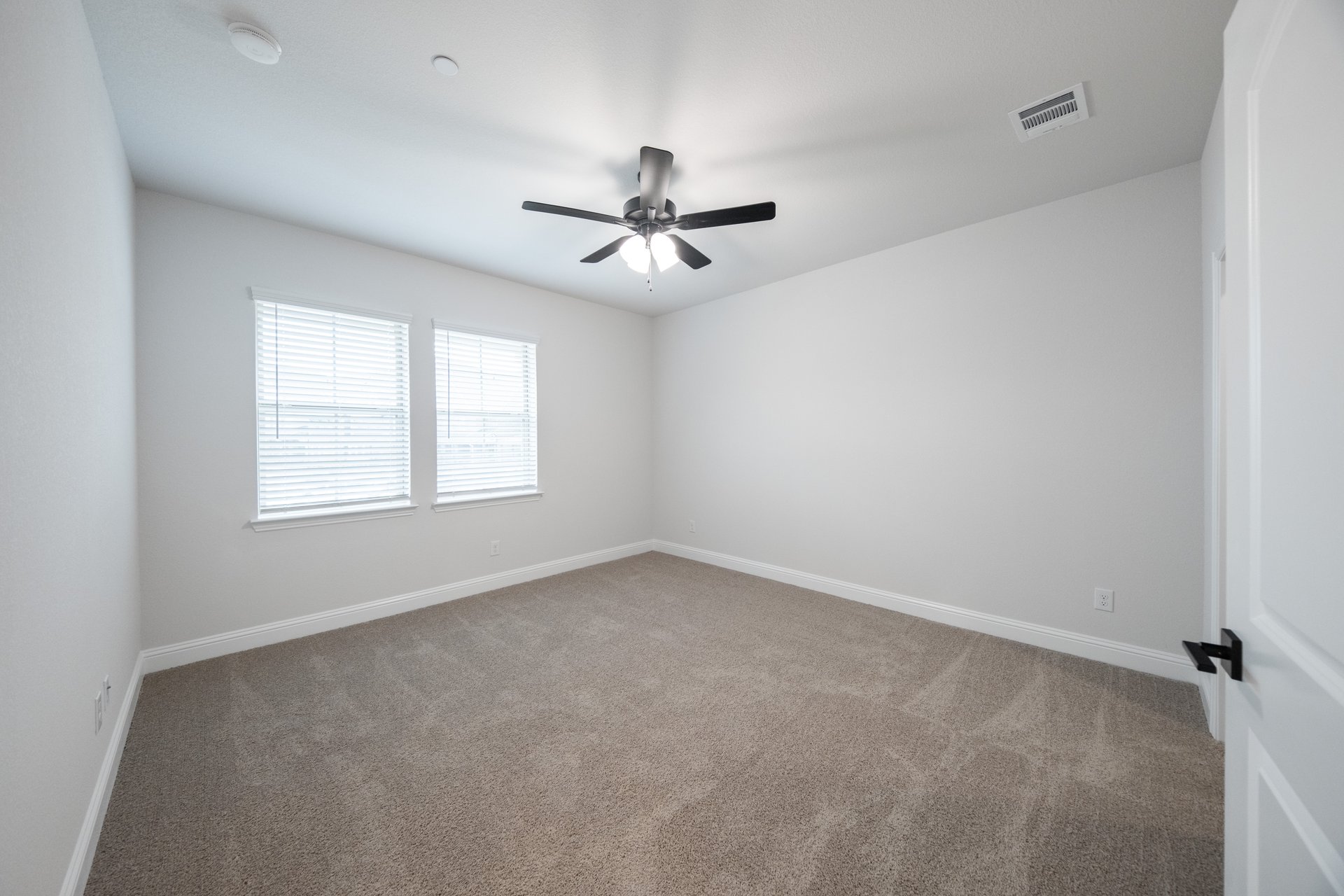 bedroom with ceiling fan and windows with blinds