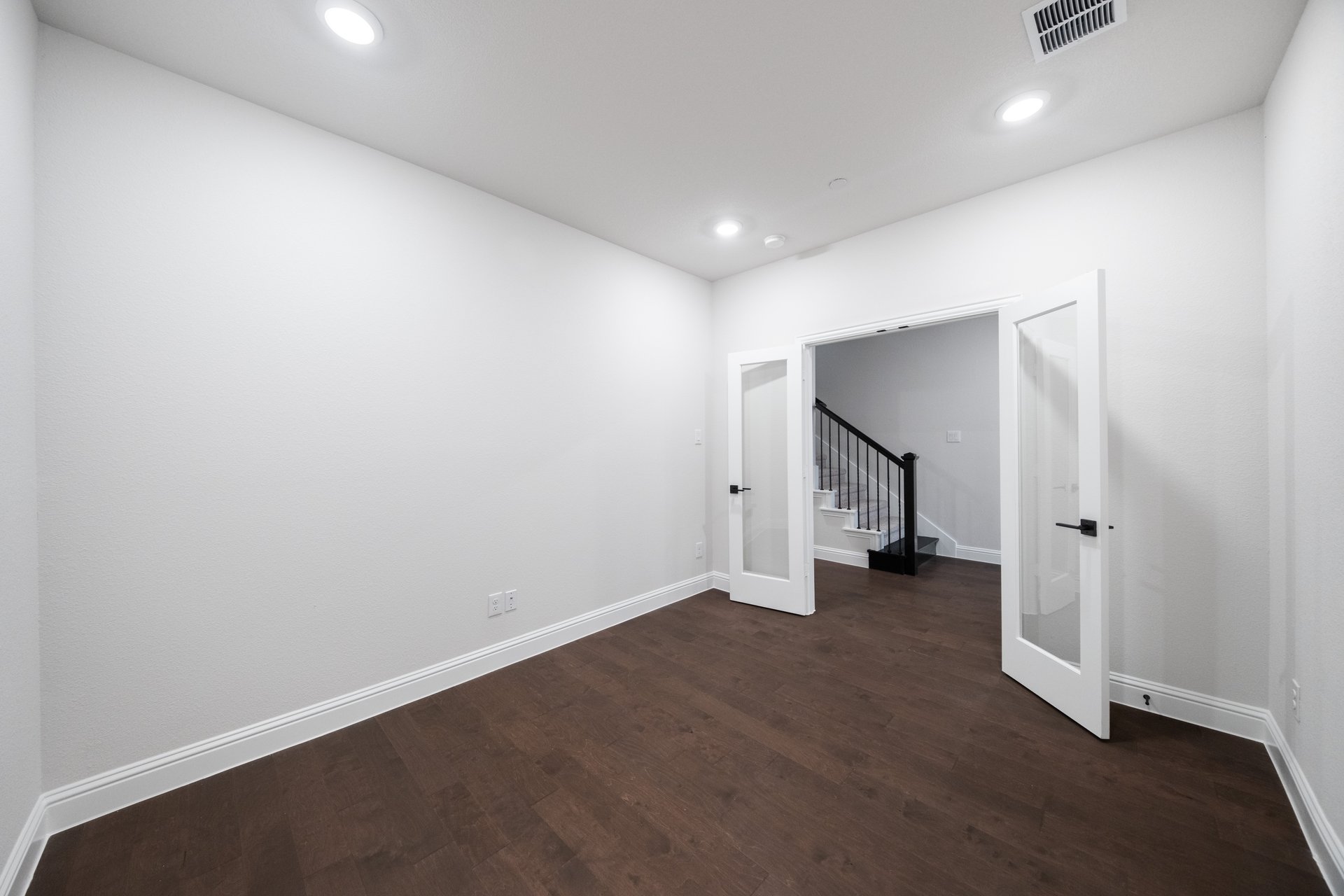 study with wood flooring and french doors