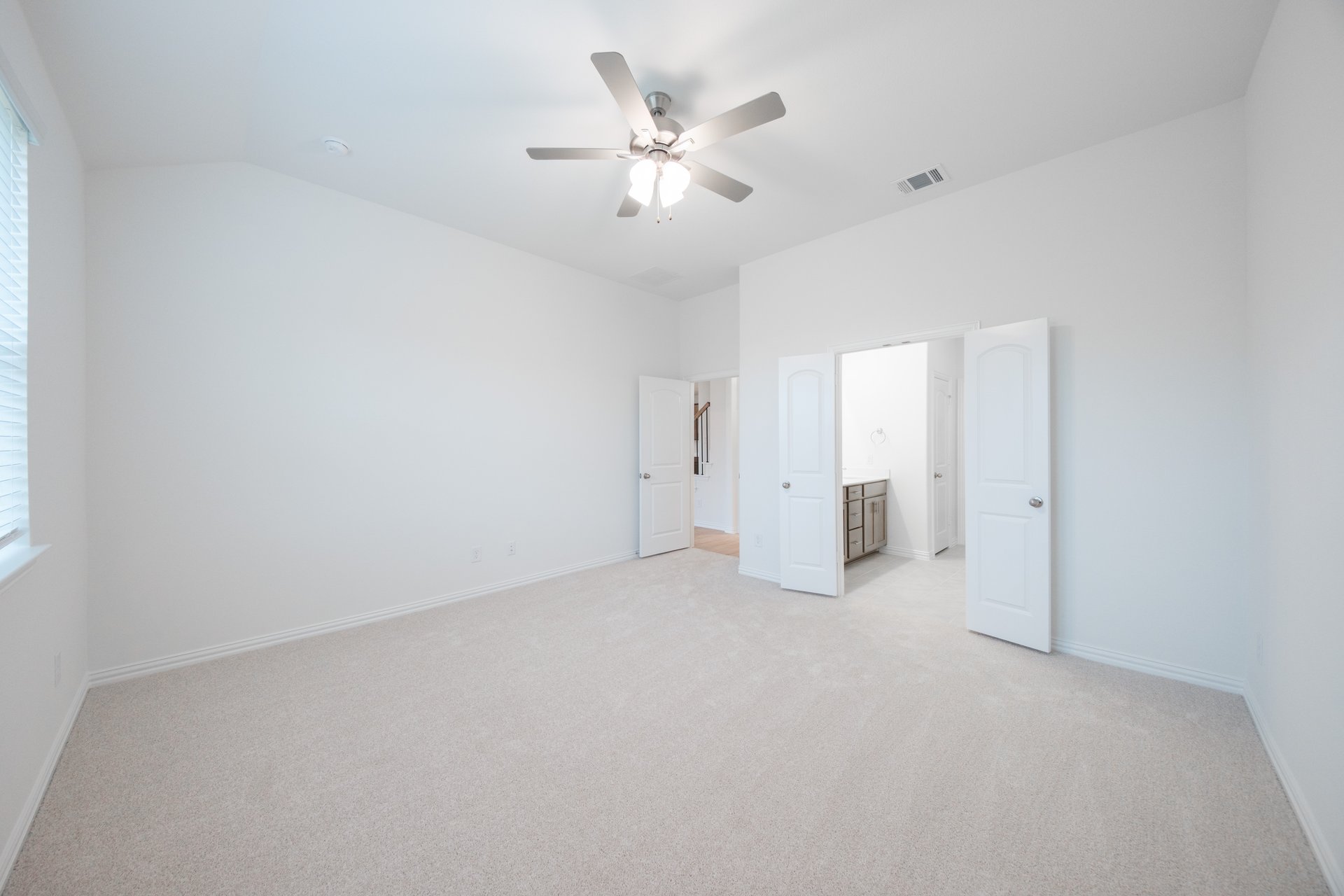 primary bedroom with carpet and ceiling fan