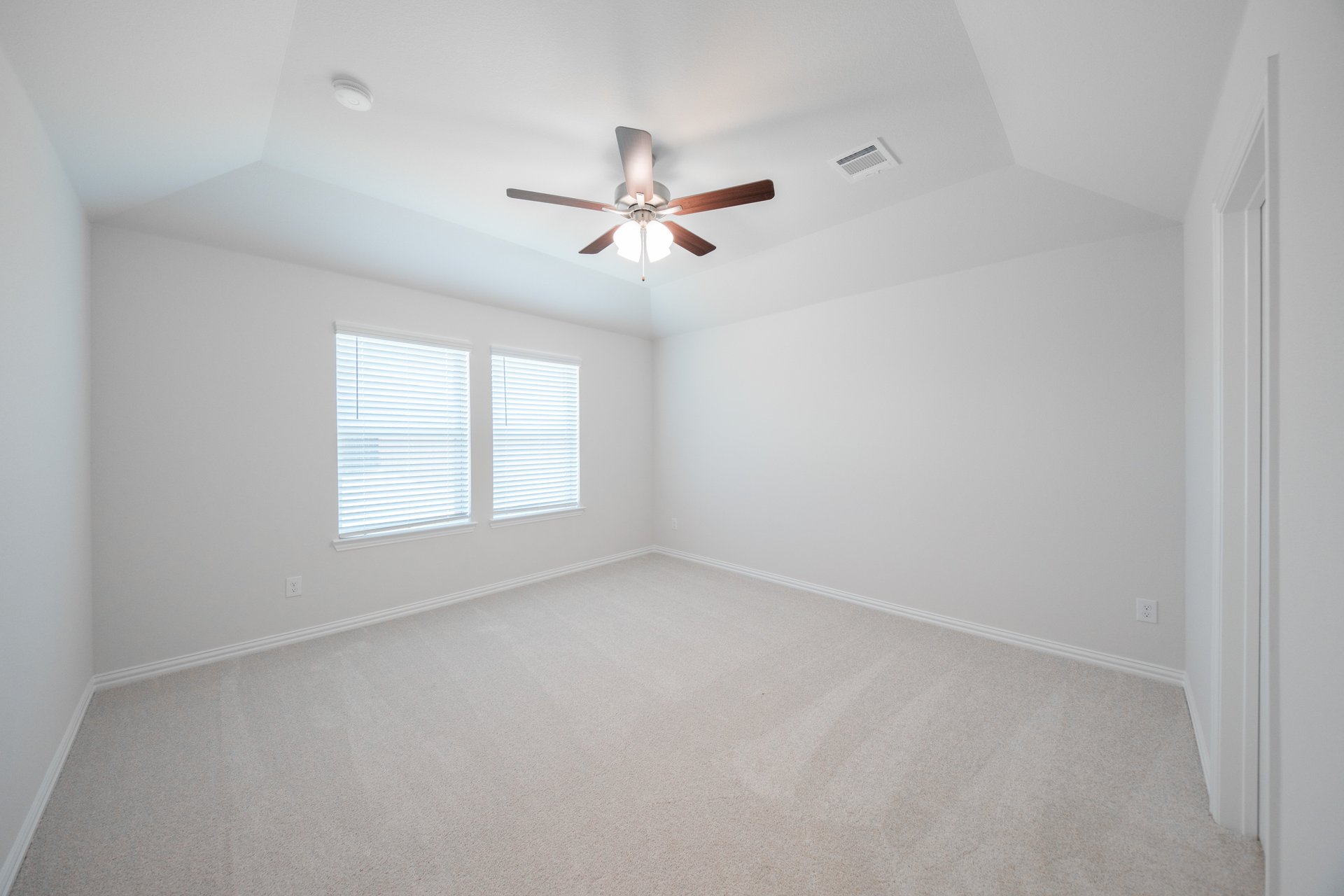 primary bedroom with carpet and ceiling fan