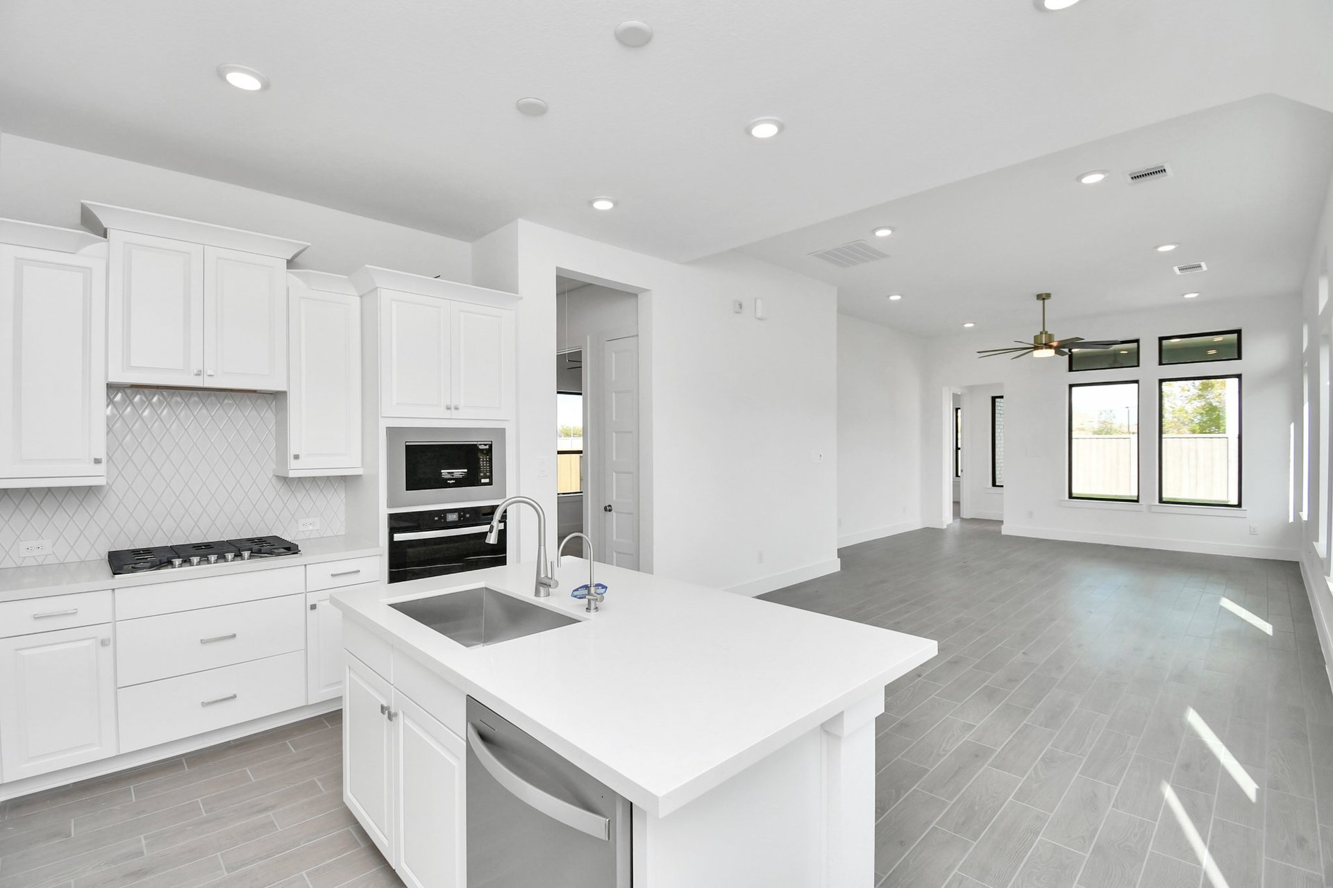 Kitchen with white cabinets and sink on the island.