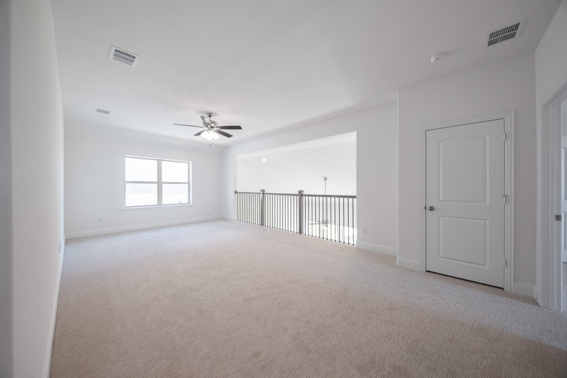 spacious loft with carpet and ceiling fan