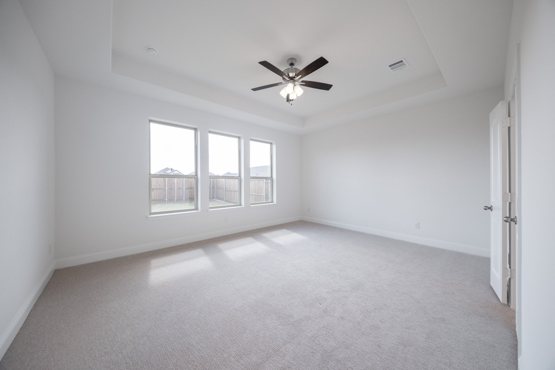 primary bedroom with carpet and windows