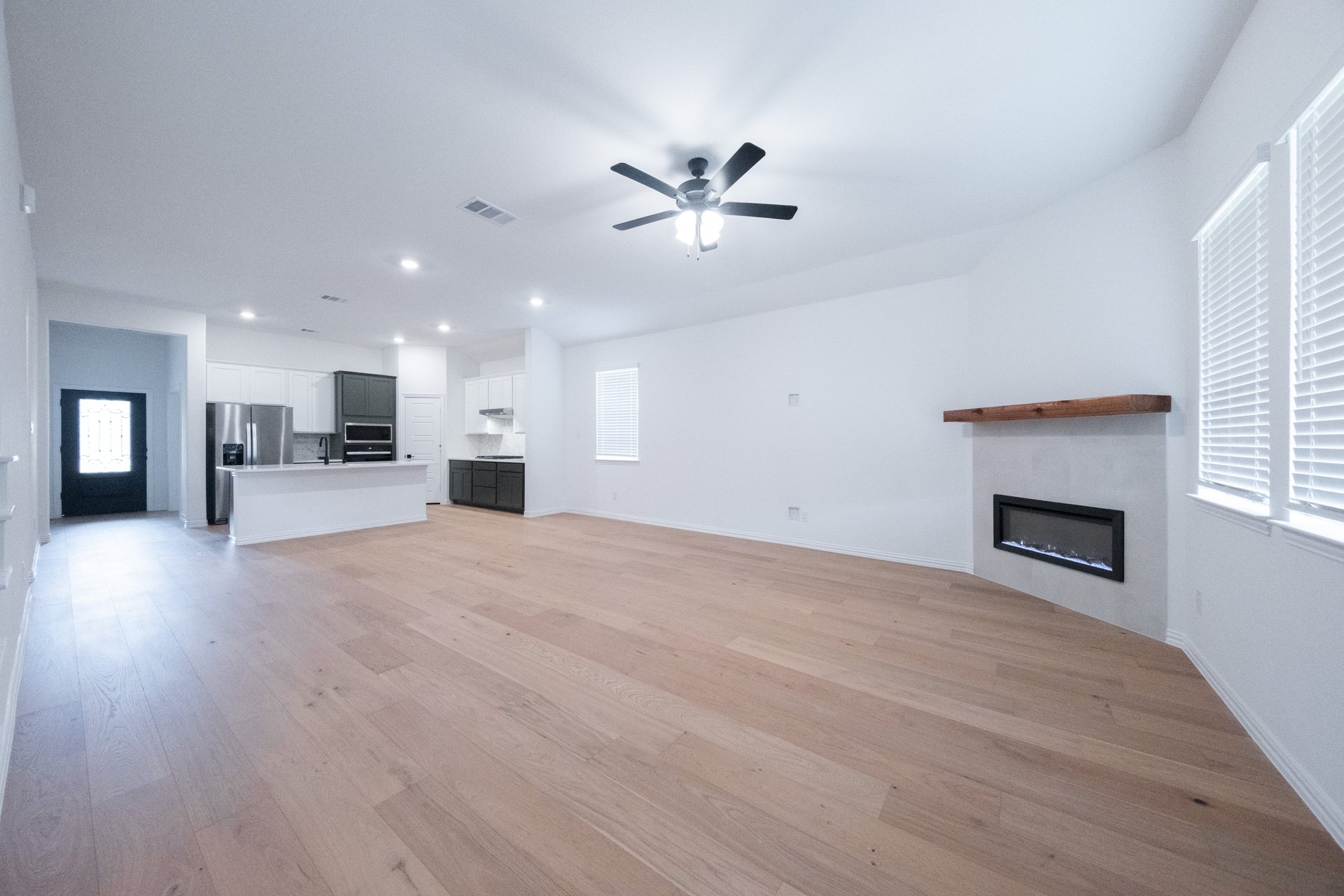 open great room with wood floors and ceiling fan
