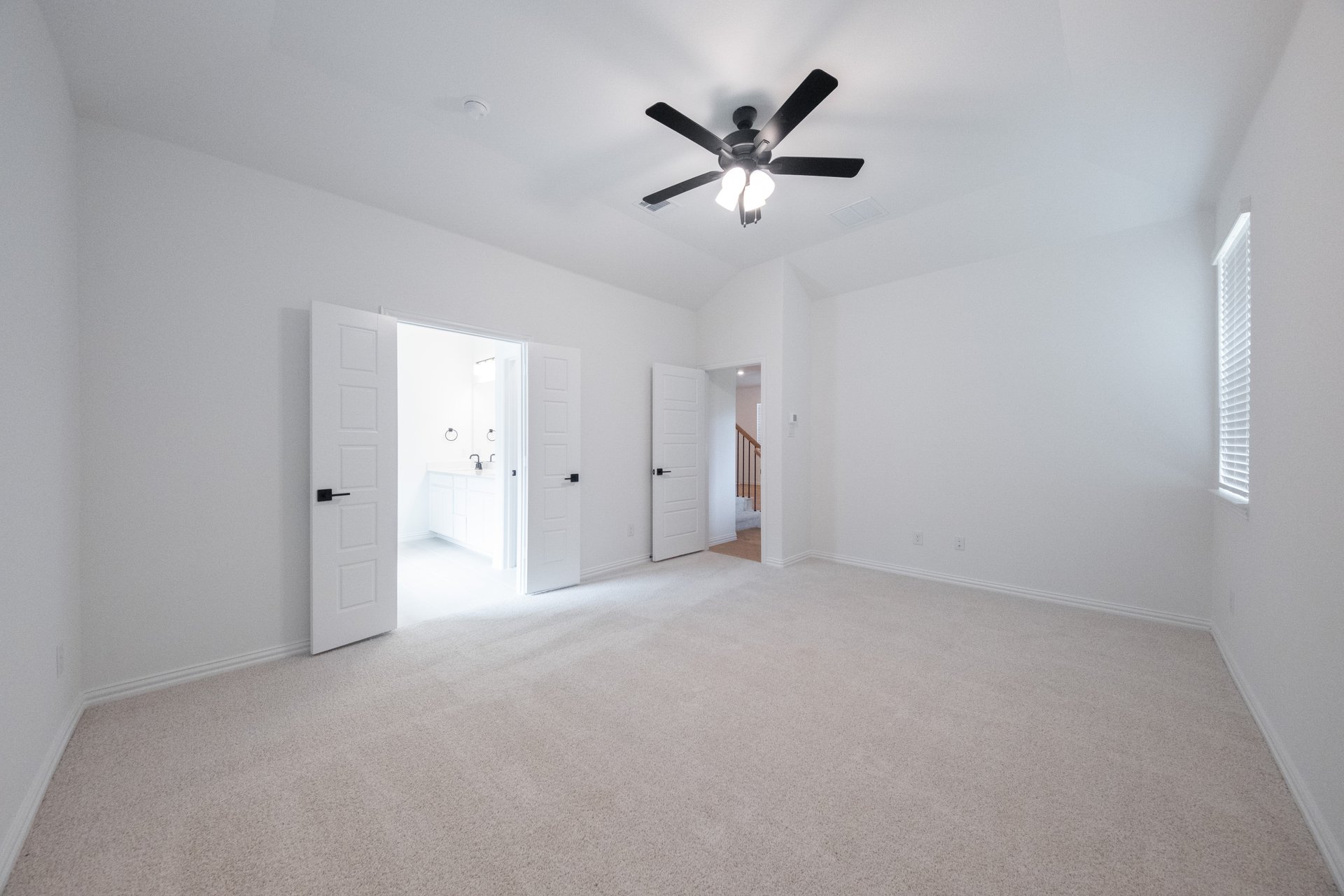 primary bedroom with carpet and ceiling fan