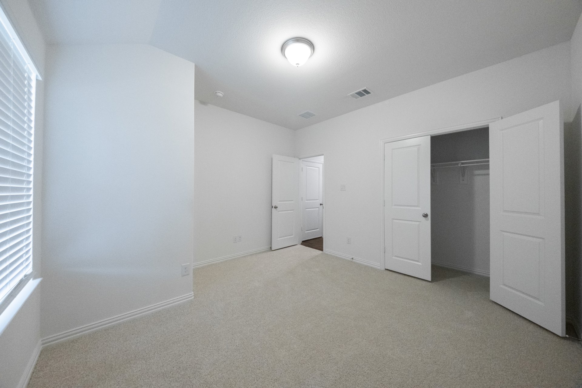 guest bedroom with carpet and walk-in closet