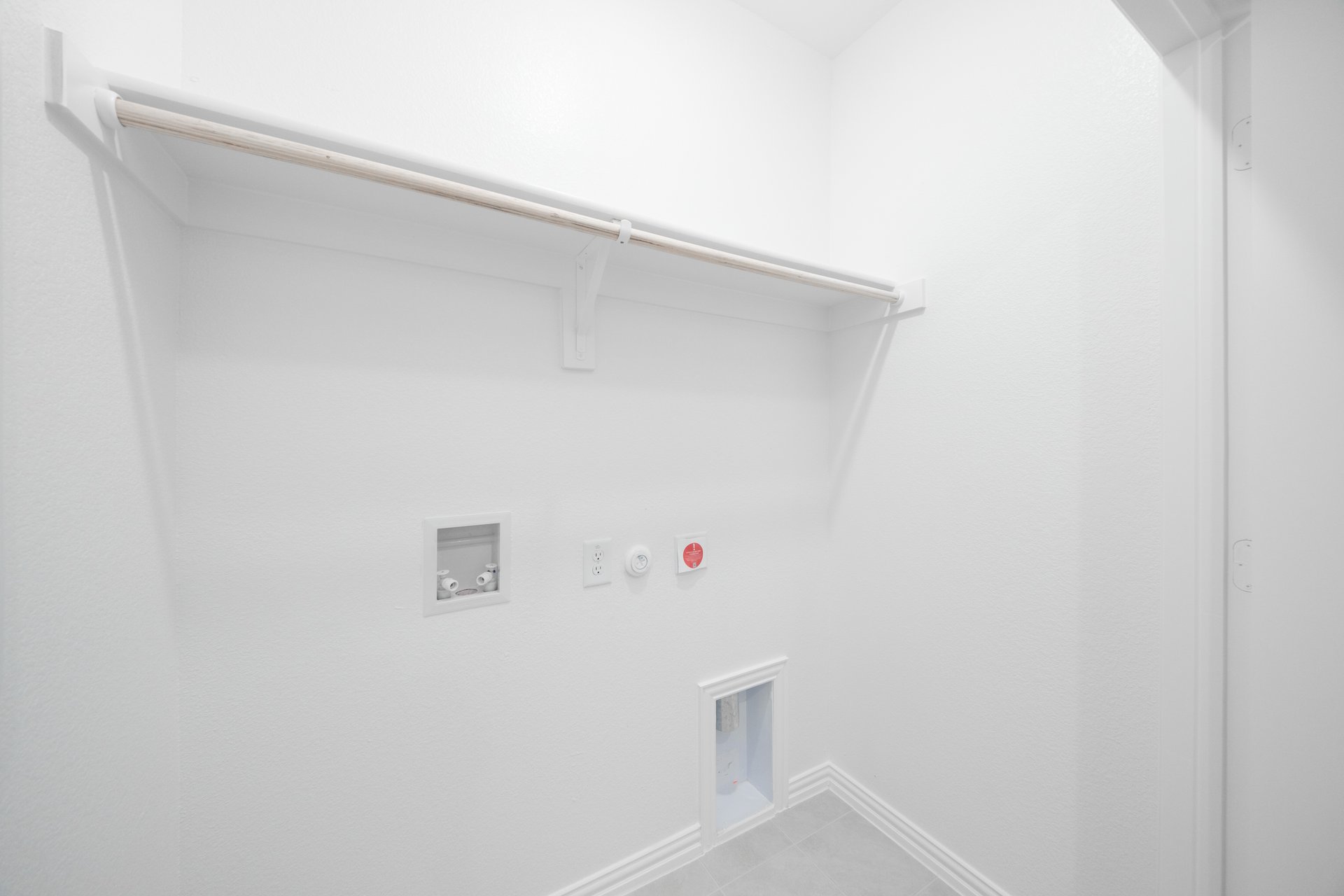 laundry room with tile floors and white shelf