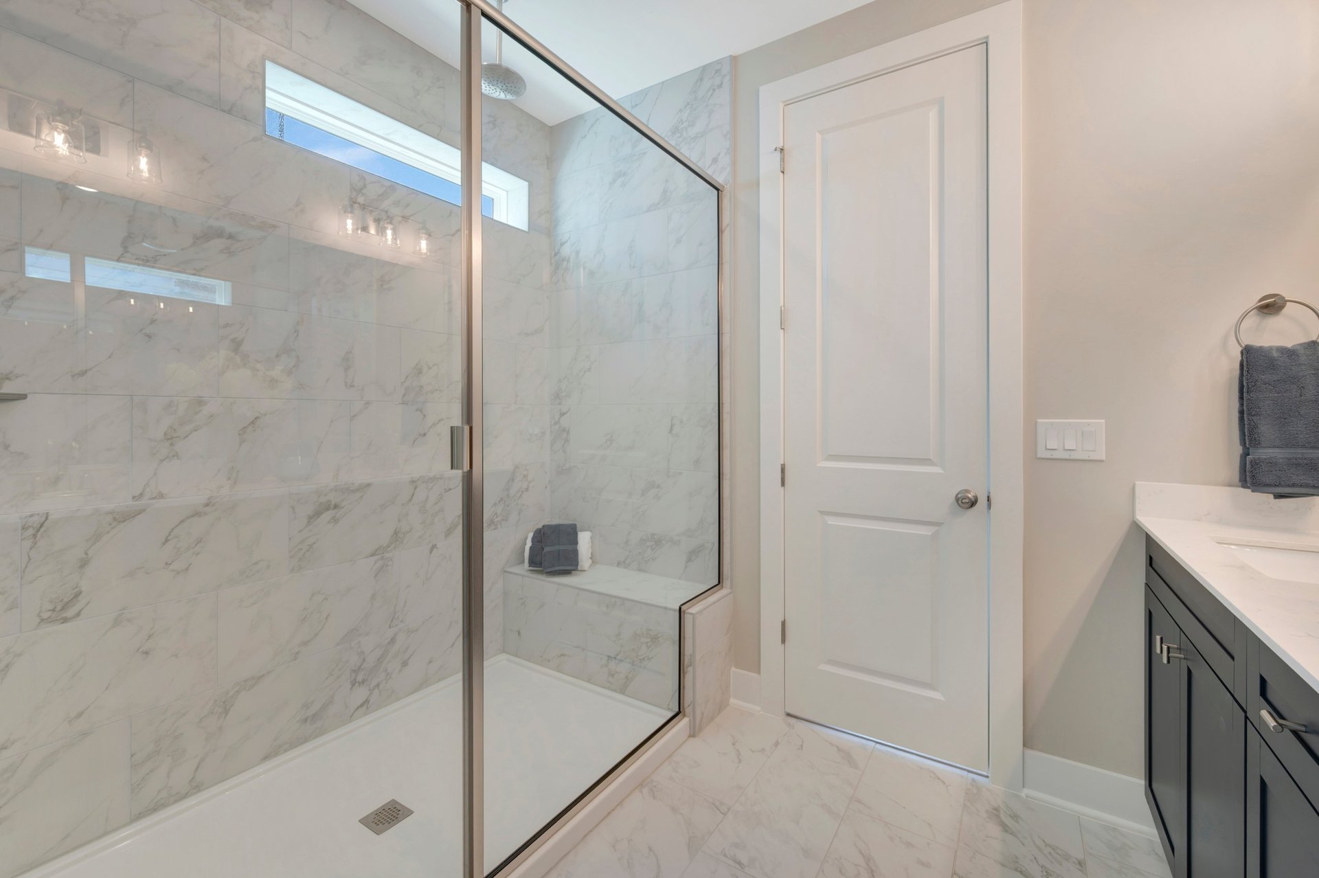 primary shower with a window and a bench
