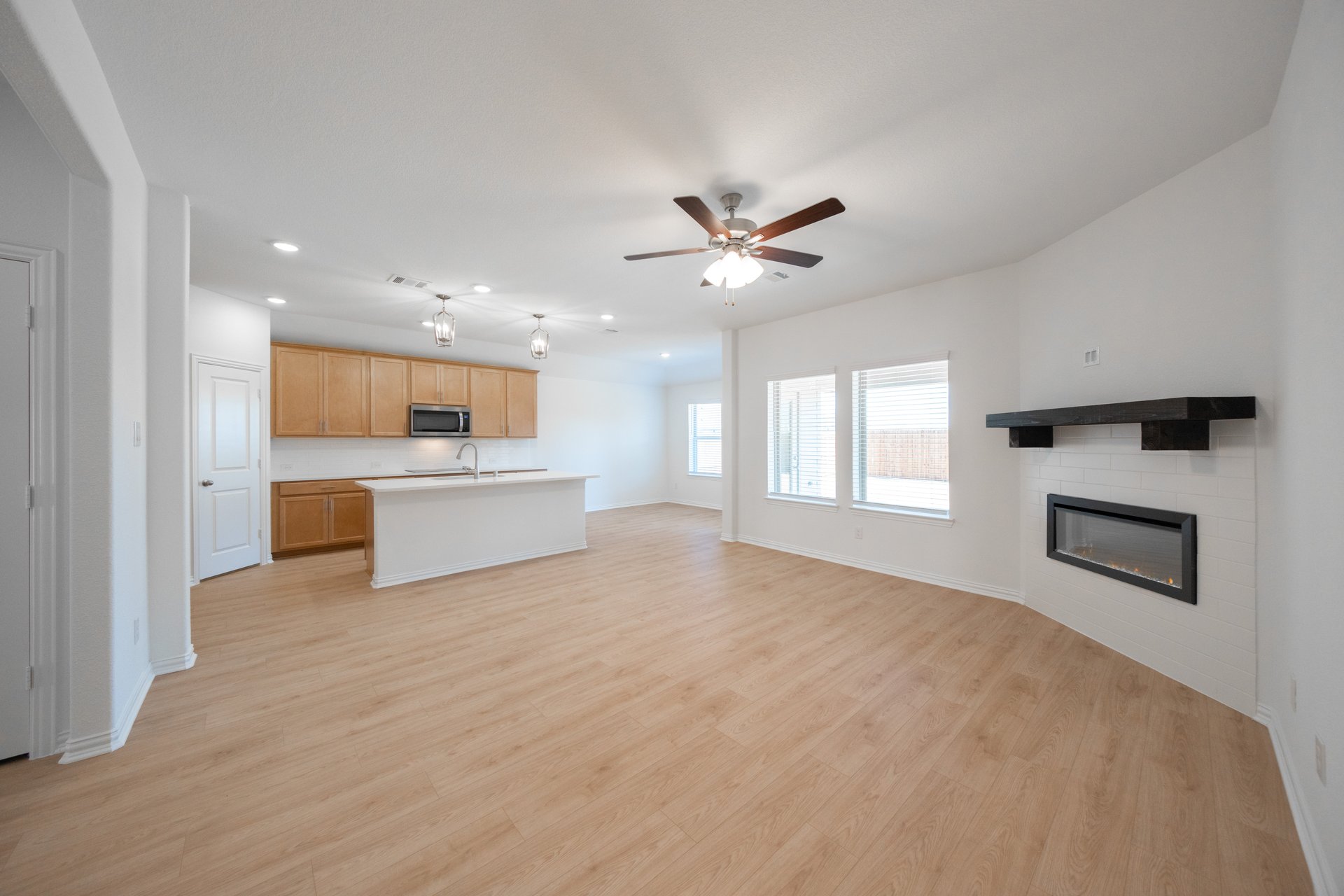 open great room with hardwood flooring and gas fireplace