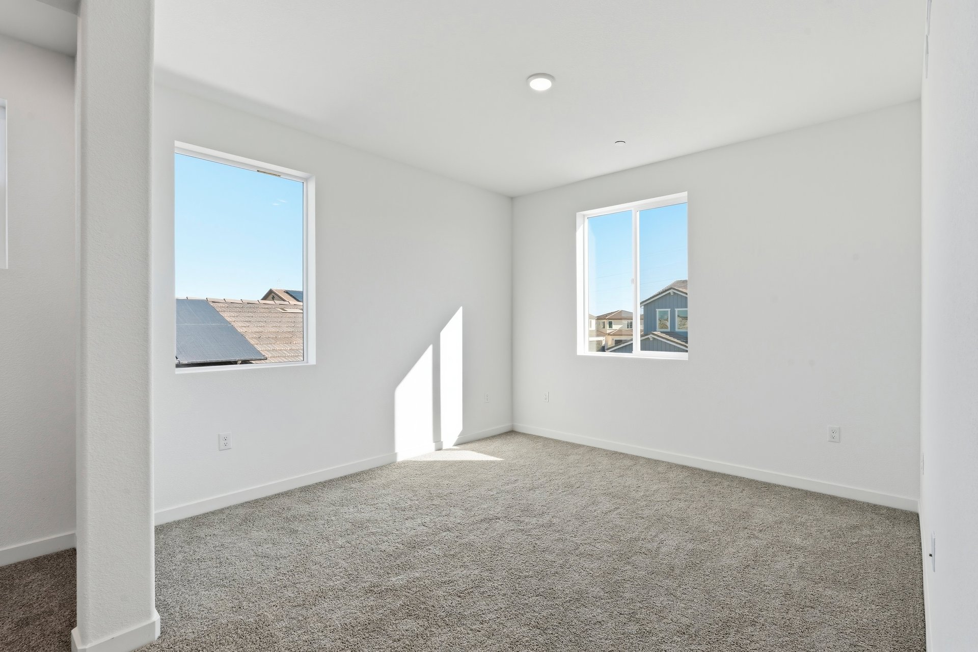 loft with gray carpet, white walls, and two windows