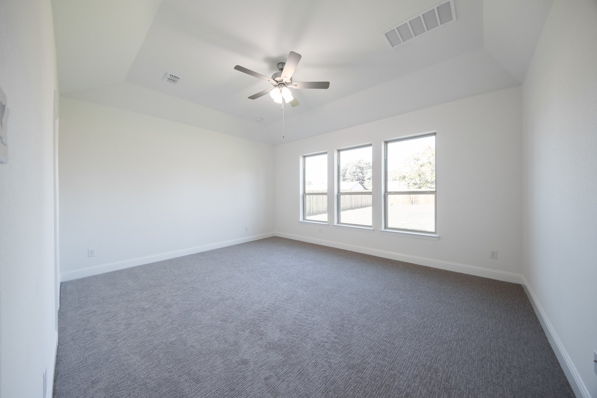 bedroom with large windows and carpet