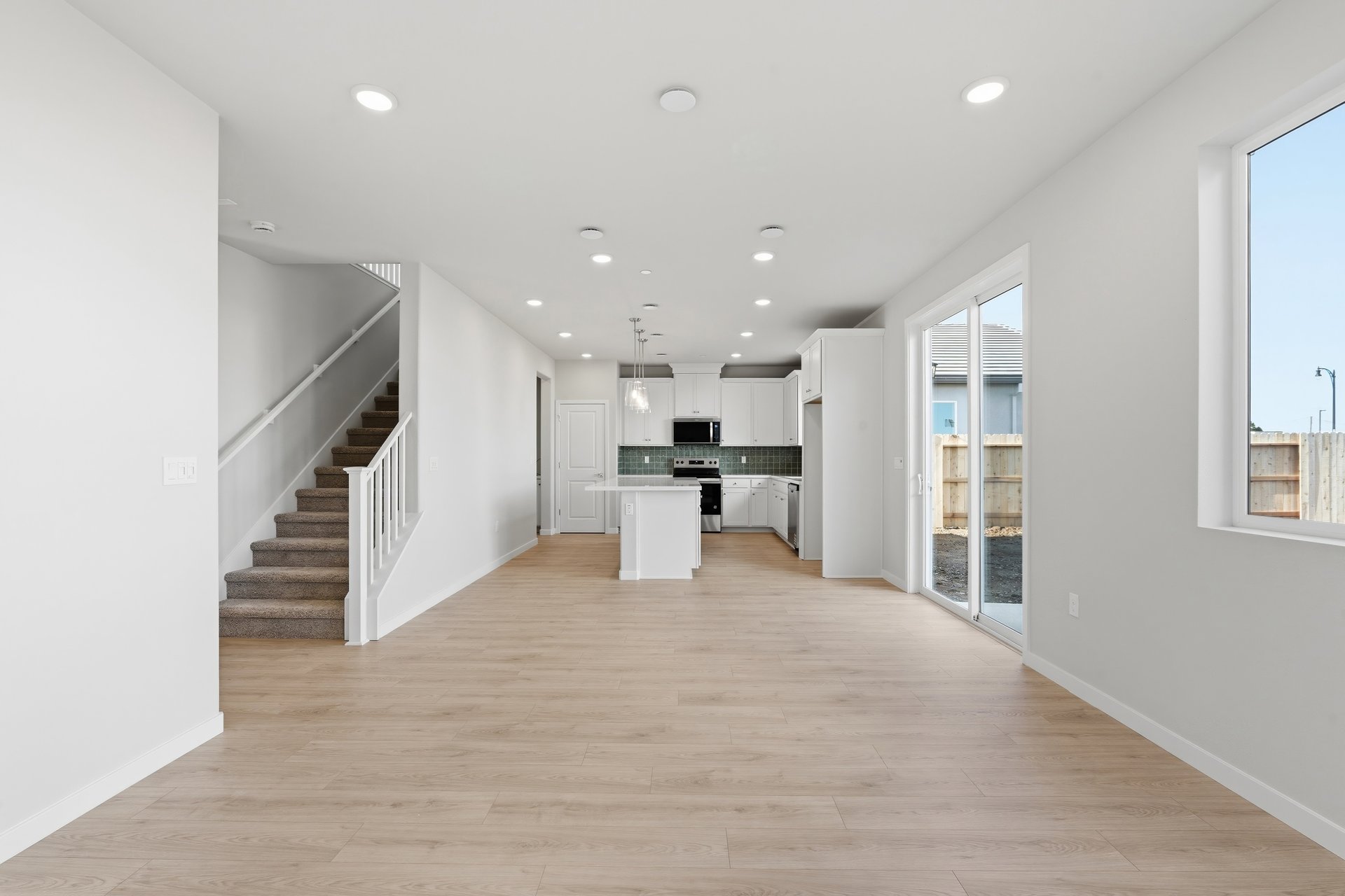 great room with light wood floors, white walls, windows, and recessed ceiling lights