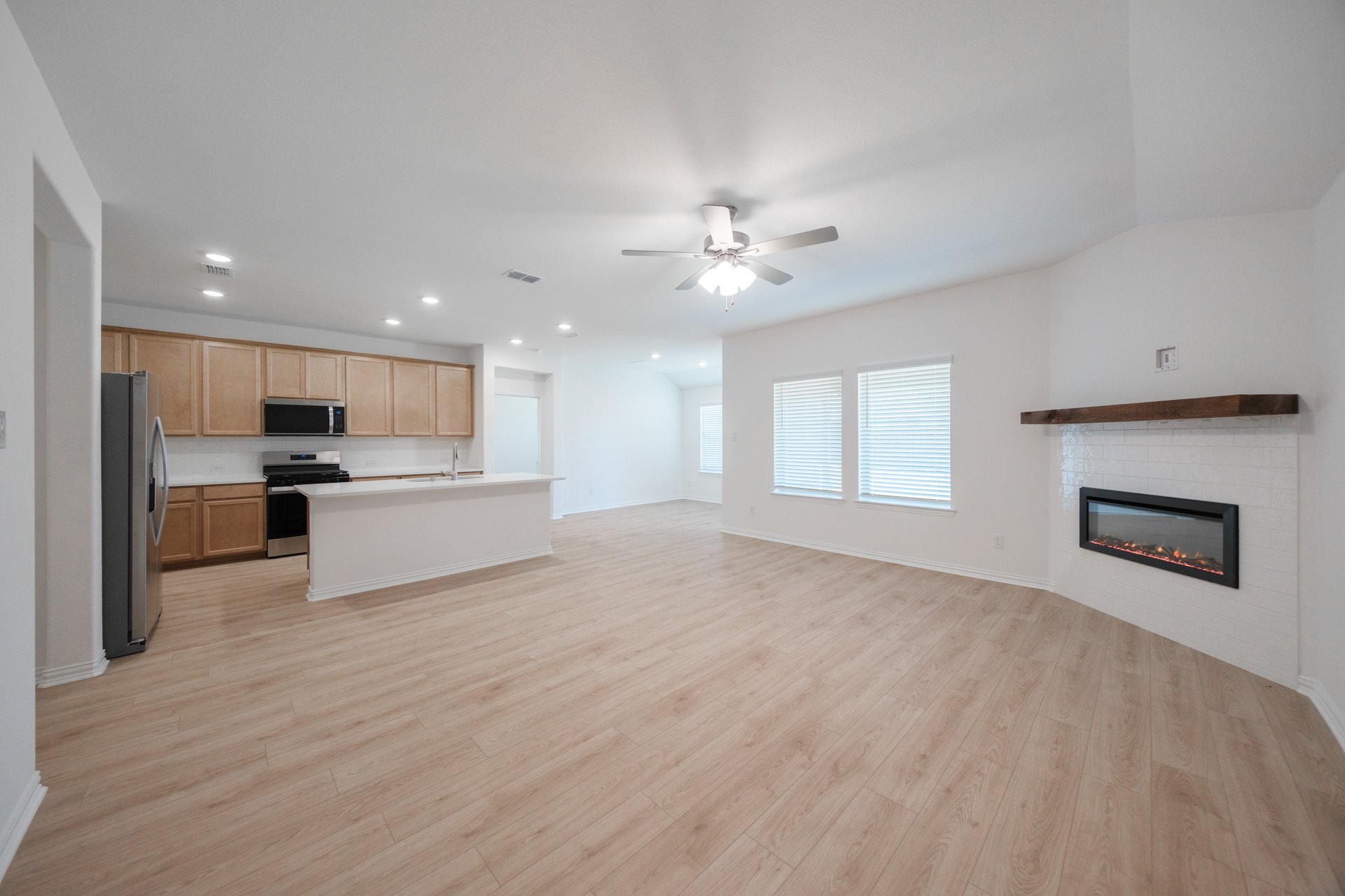 open great room with wood floors and fireplace